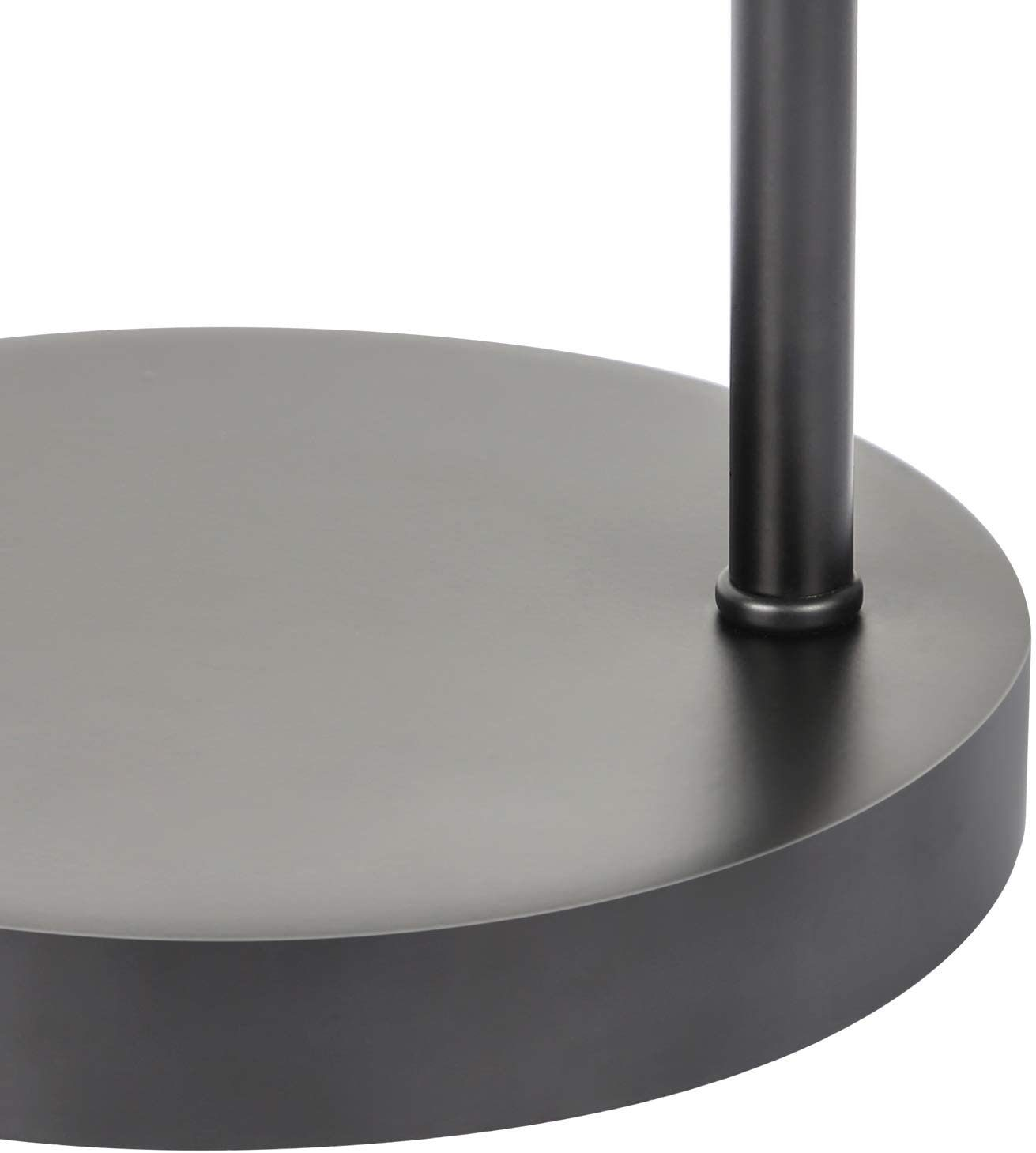 Zbliżenie podstawy czarnej lampy. Podstawa jest okrągła i ciemna.