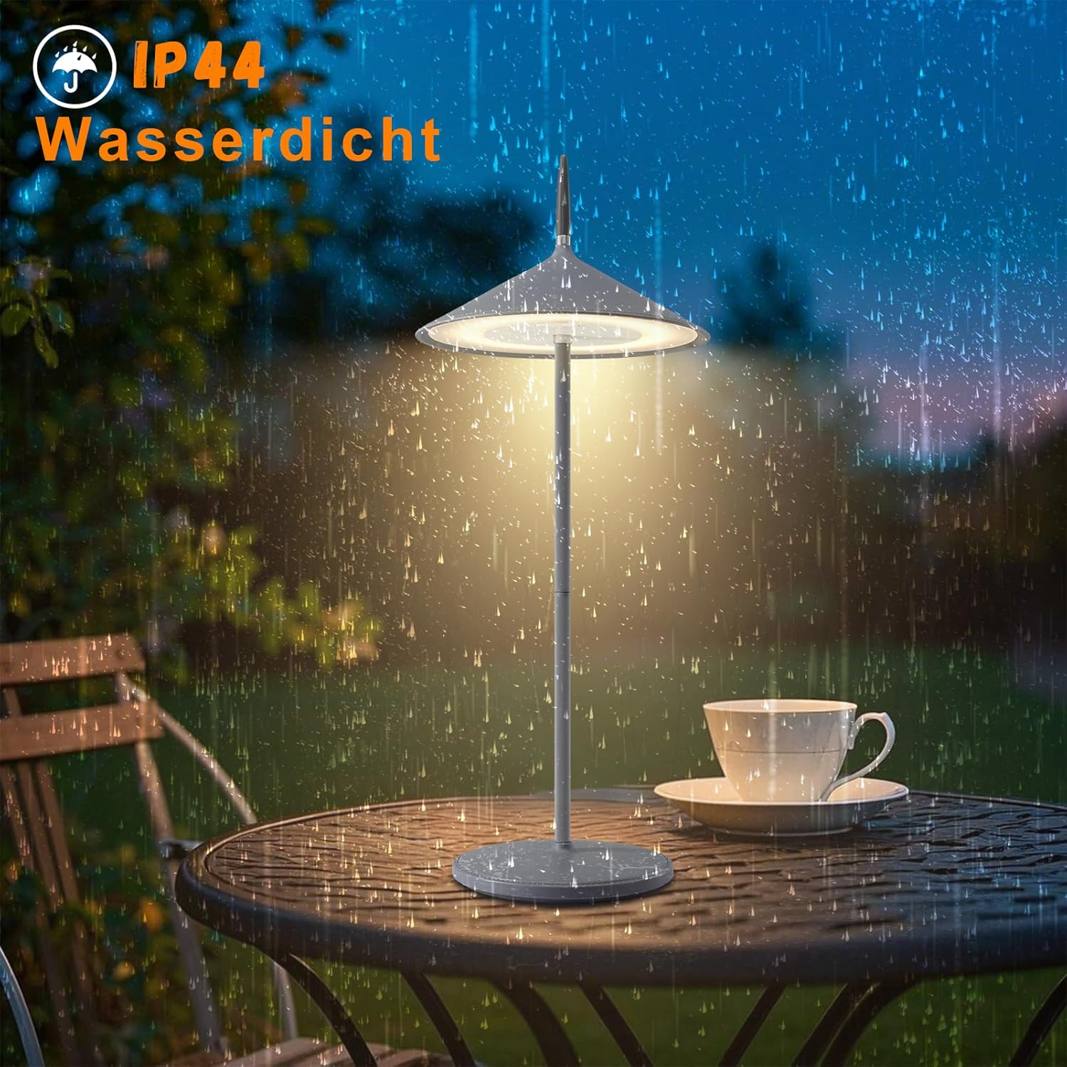 Lampa na stole w deszczu. Na stole stoi filiżanka i spodek.