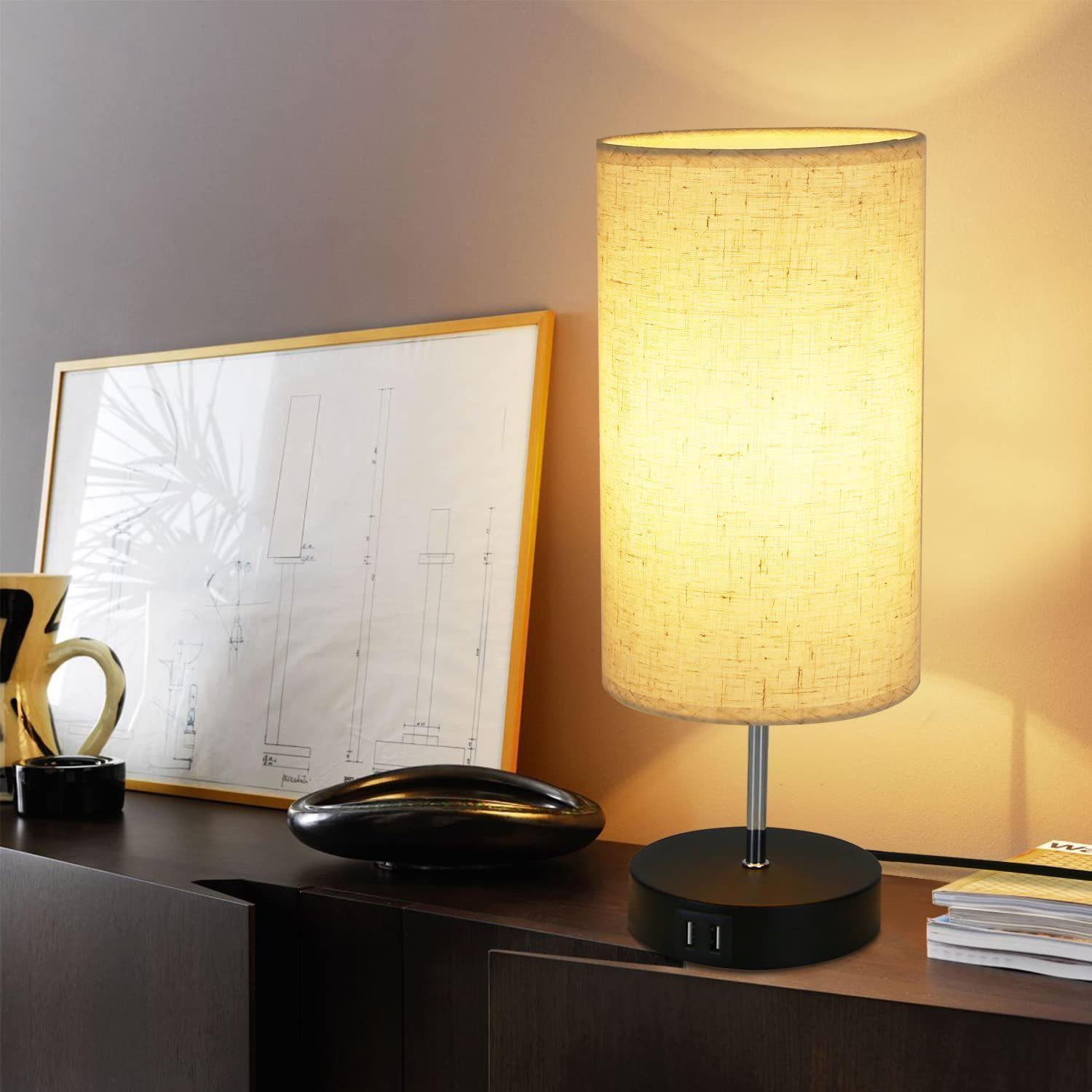 Podświetlona lampa cylindryczna z czarną podstawą i portami USB, na ciemnej drewnianej powierzchni.