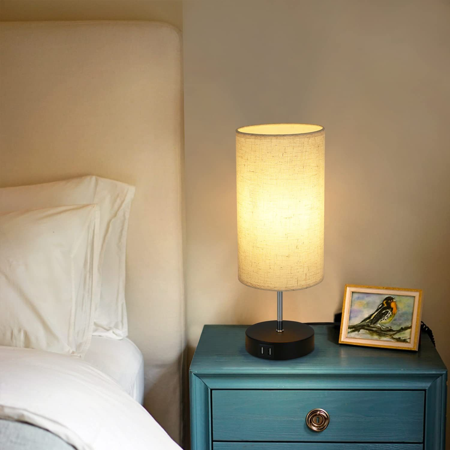 Podświetlana lampa cylindryczna z ramką na zdjęcia i łóżkiem w tle.