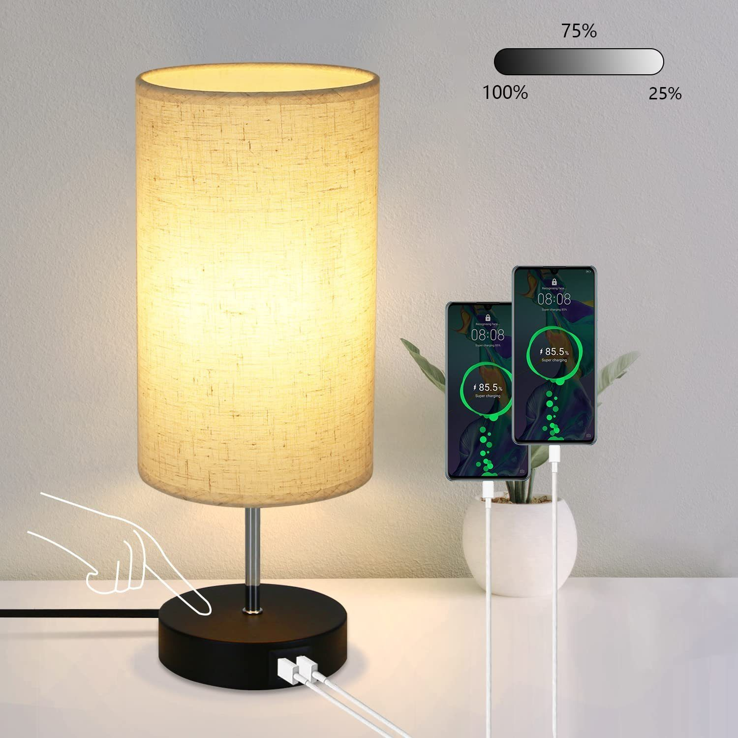 Una lampada da tavolo con paralume beige. Due telefoni sono in carica. Una mano tocca la base della lampada.