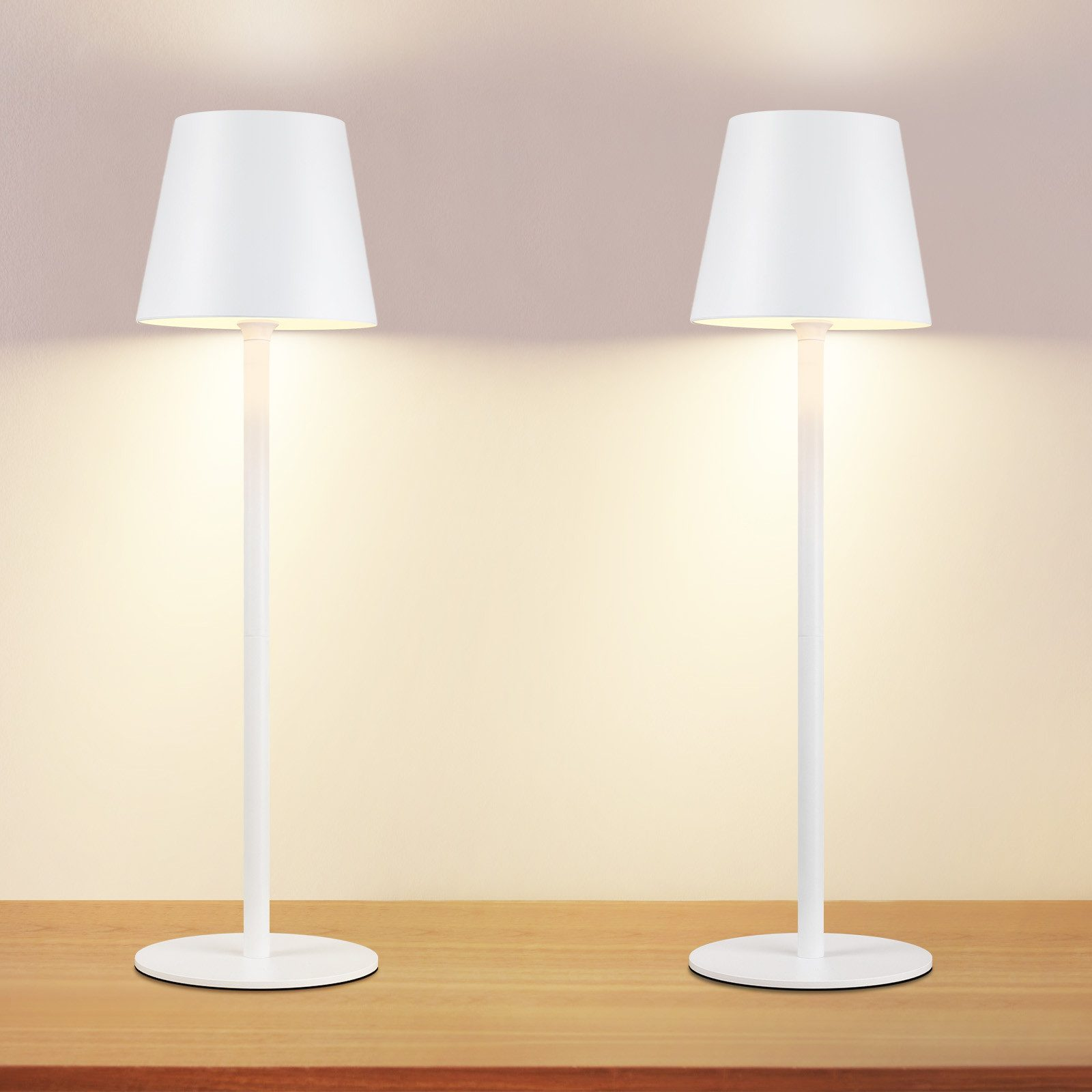 Dwie białe, nowoczesne lampy. Mają prosty design i stoją na stole.