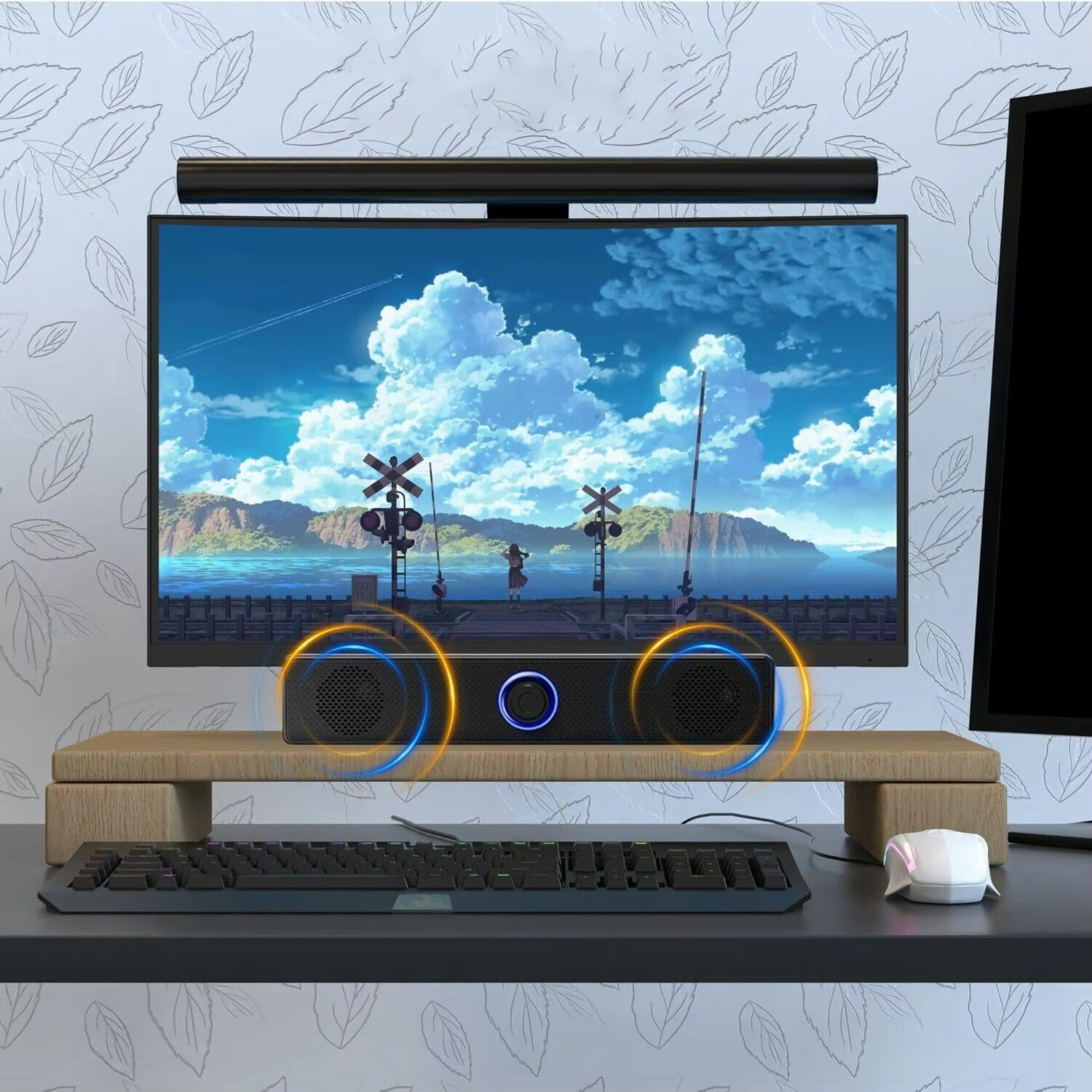 Konfiguracja komputera z ekranem, soundbarem, klawiaturą i myszą.