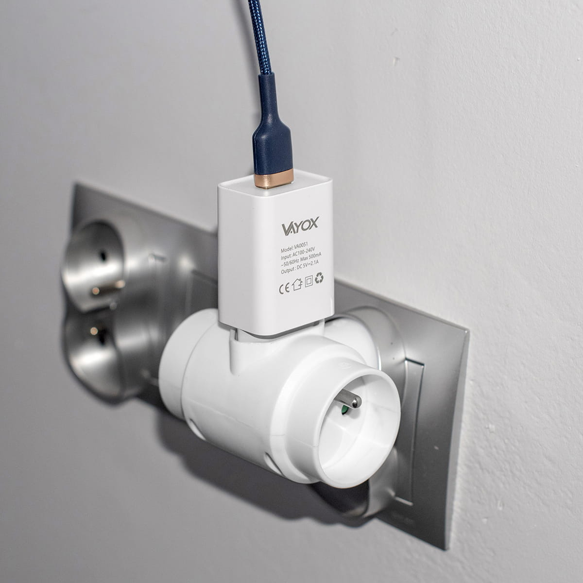 Ładowarka podłączona do gniazda elektrycznego z drugim adapterem.