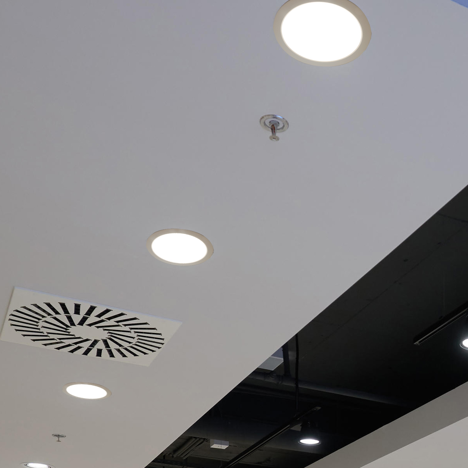 Un techo con múltiples luces LED empotradas y un sistema de ventilación. Esquema de color blanco y negro.