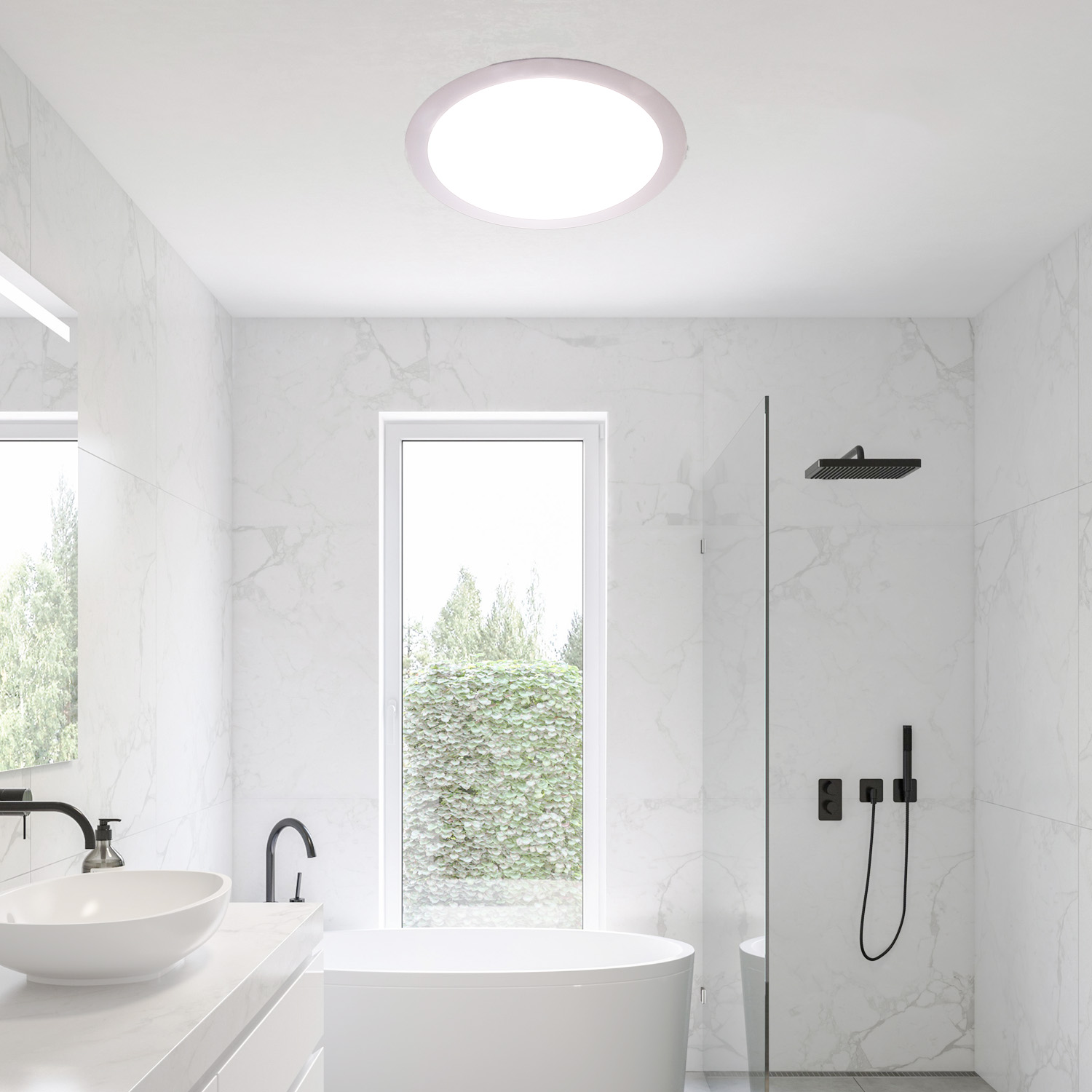 Un baño moderno con baldosas de mármol blanco, una gran luz circular en el techo y una ventana con vistas a vegetación.
