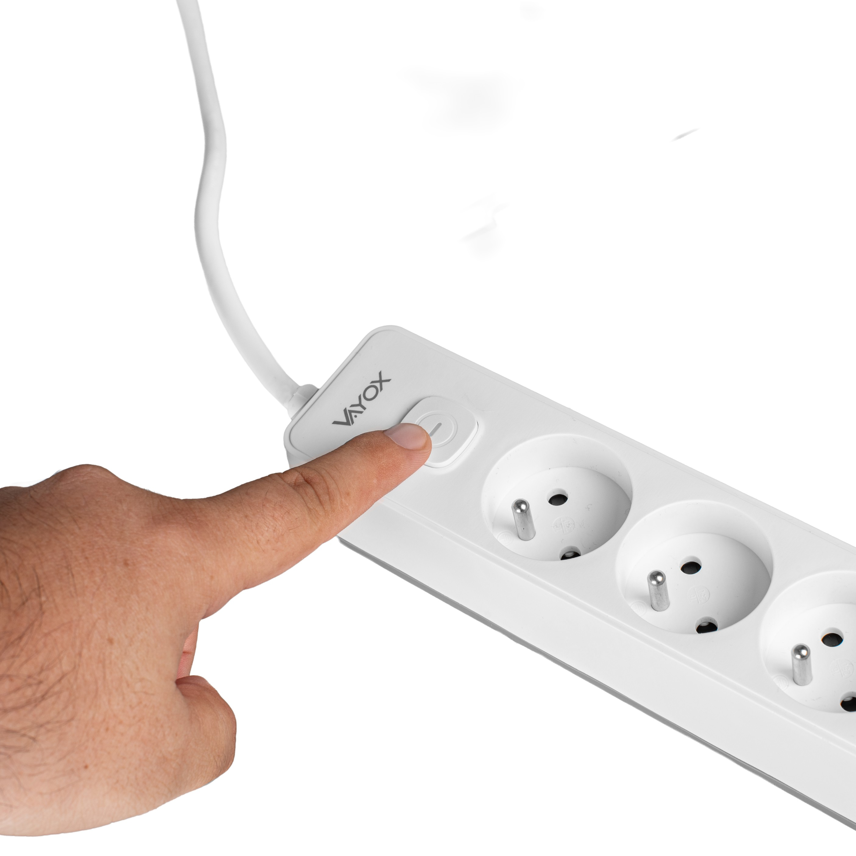Ręka naciska przycisk zasilania na białej listwie z trzema gniazdami. Białe tło.