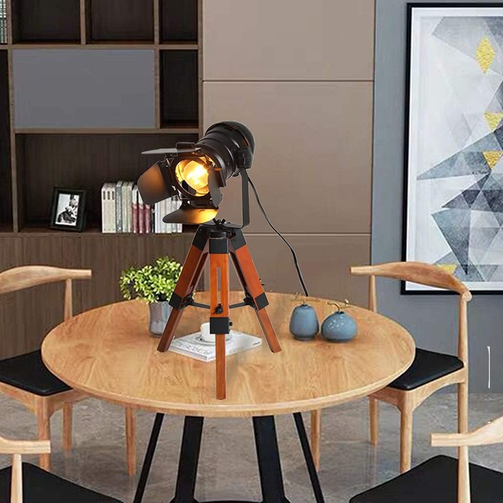 Un foco sobre un trípode de madera, sobre una mesa de madera en un entorno de habitación.