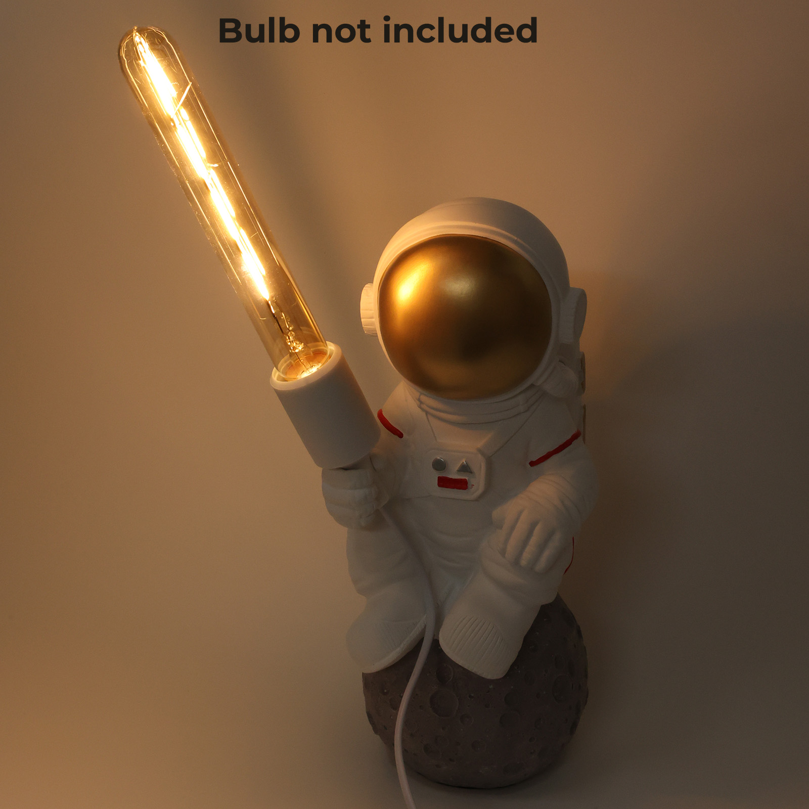 Lámpara de astronauta sentada en una luna sosteniendo una bombilla, iluminación cálida.