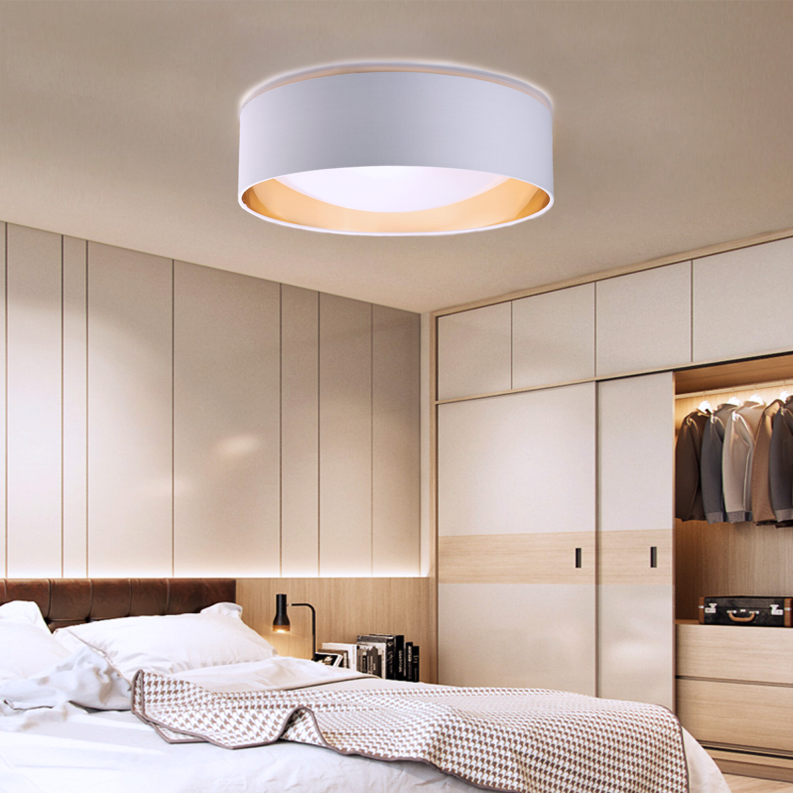 Un dormitorio con una lámpara de techo y una cama con manta estampada.