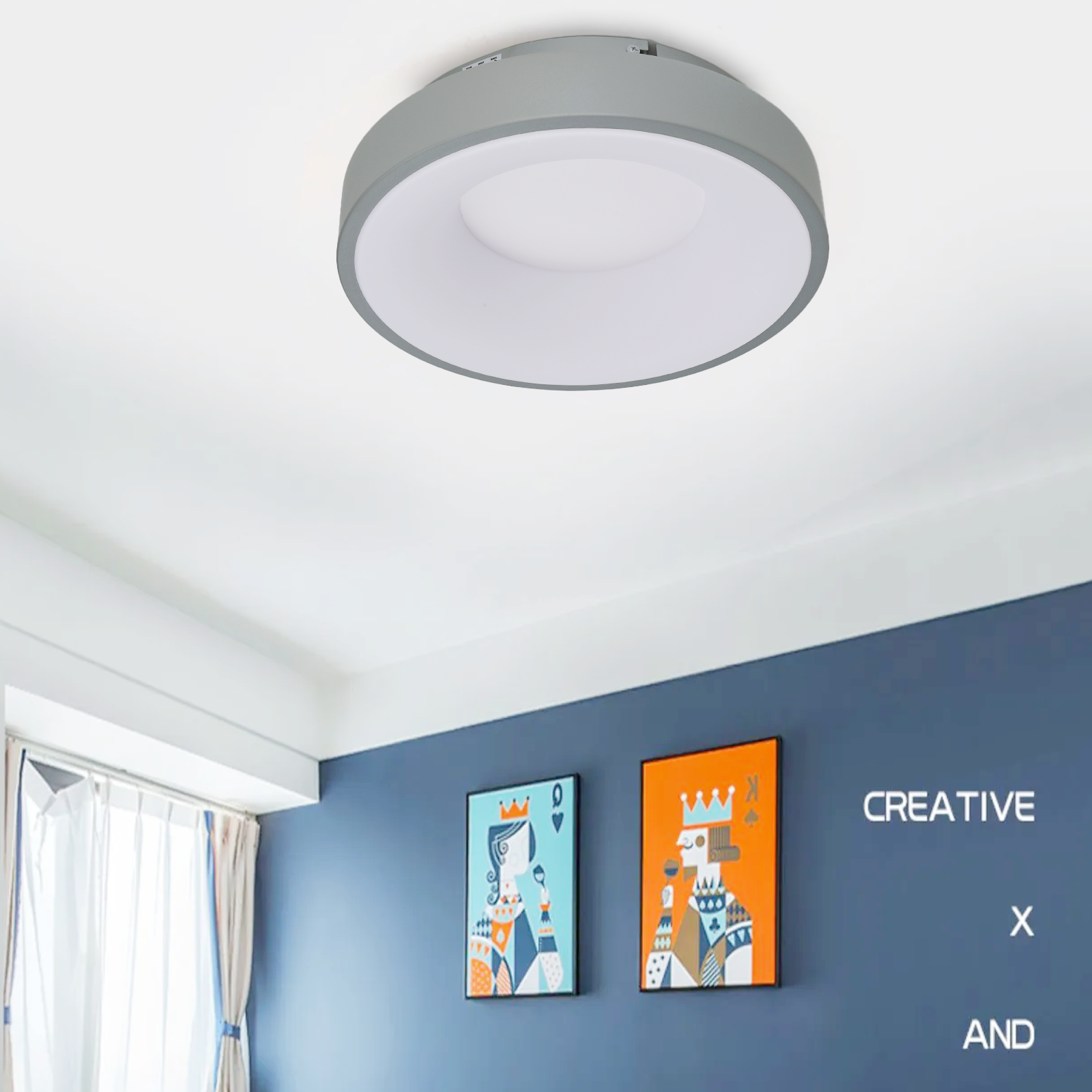 Una habitación con una lámpara de techo y dos cuadros en una pared azul.