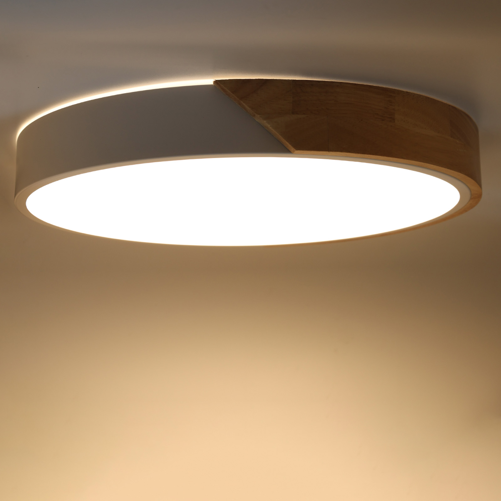 Una lámpara de techo con borde de madera y centro blanco, desde un ángulo cercano. La luz está encendida.