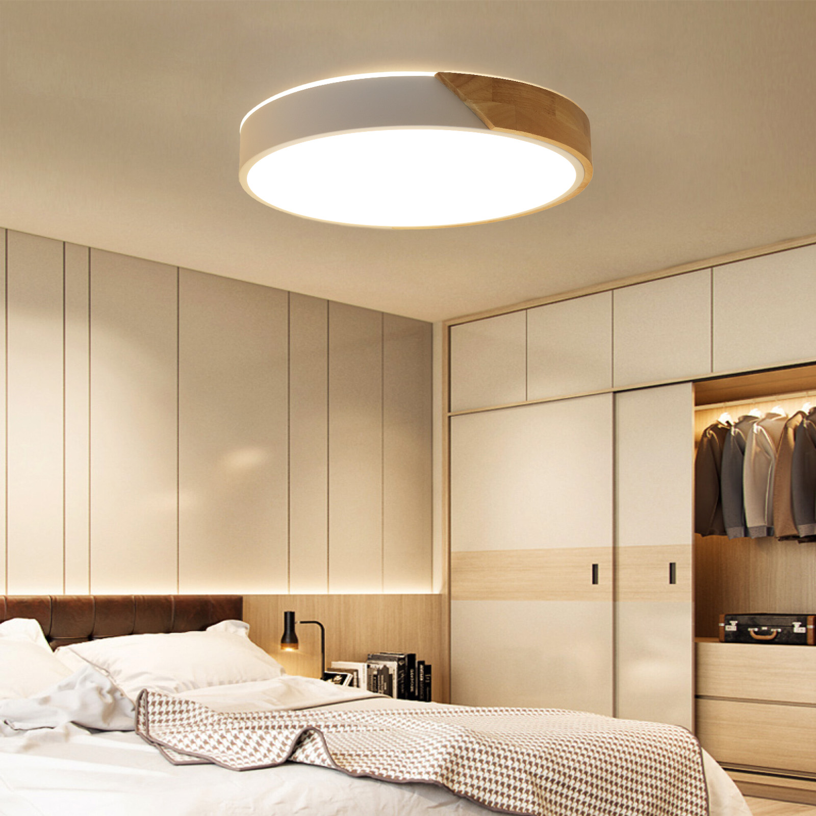 Una lámpara de techo circular. Tiene un marco de madera y una luz blanca en el interior. Dormitorio en el fondo.