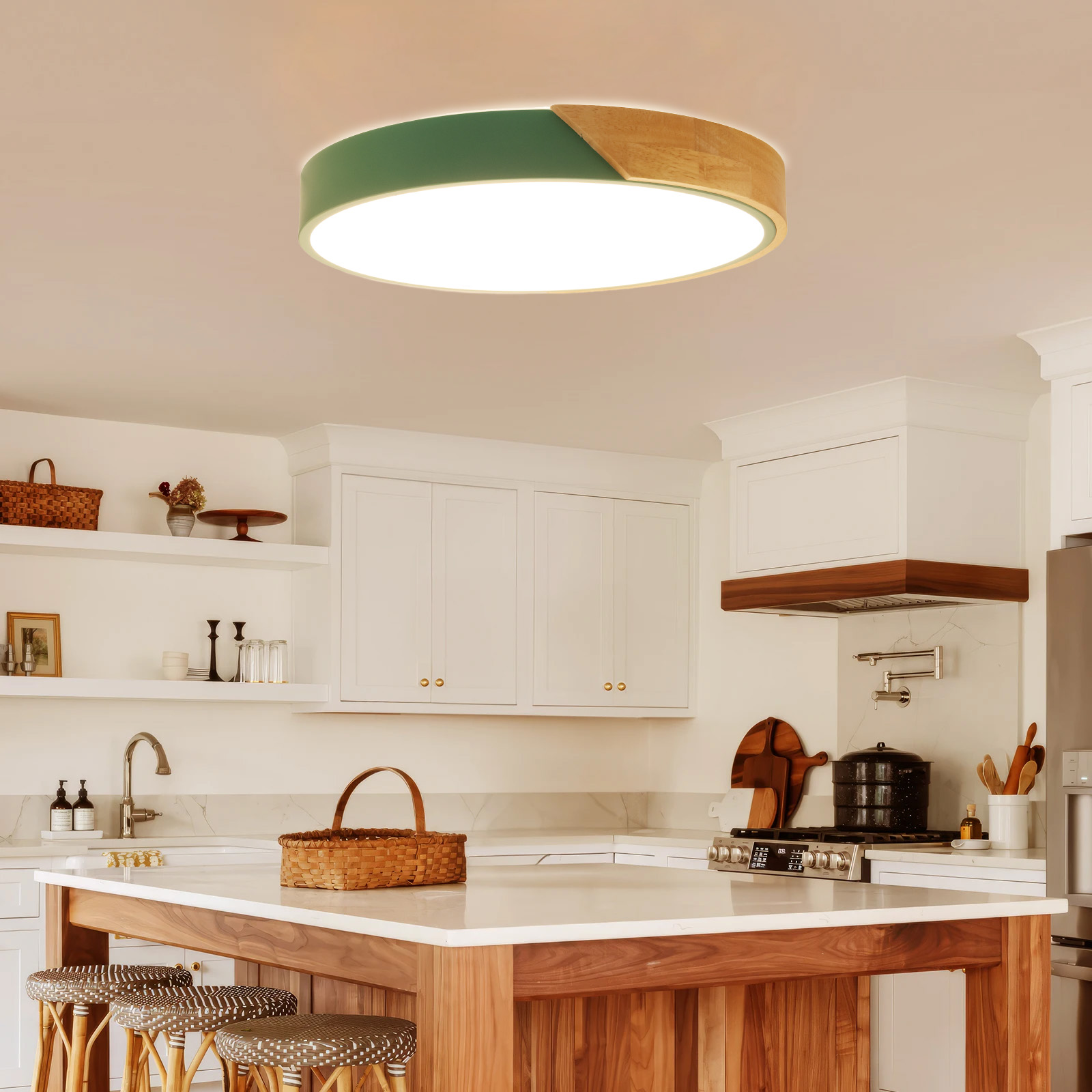 Cocina con una lámpara de techo redonda. La lámpara tiene secciones verdes, de madera y blancas. En el fondo hay armarios blancos.