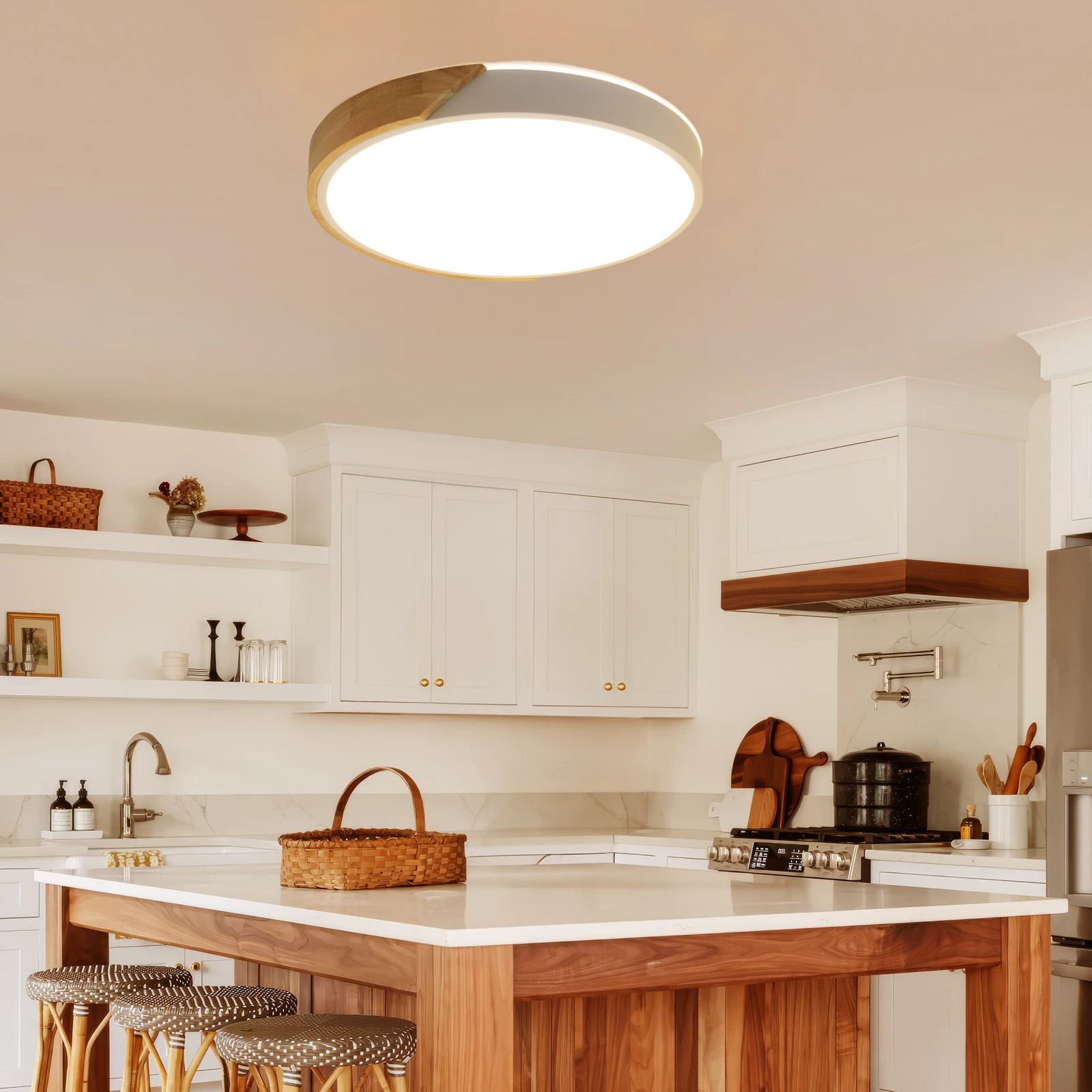 Una cocina con una lámpara de techo, isla de madera, gabinetes blancos y varios utensilios de cocina.