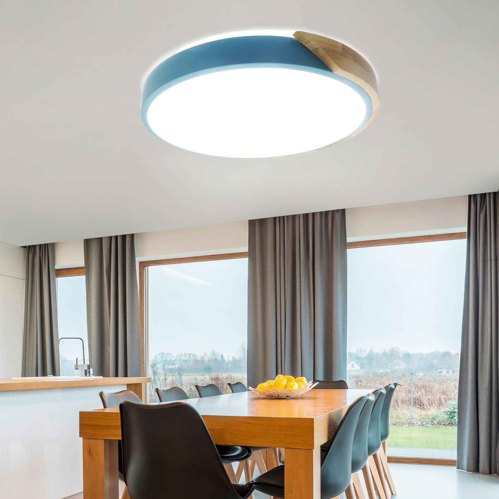 Una moderna luz de techo con borde azul y madera, instalada en una habitación con mesa de comedor.