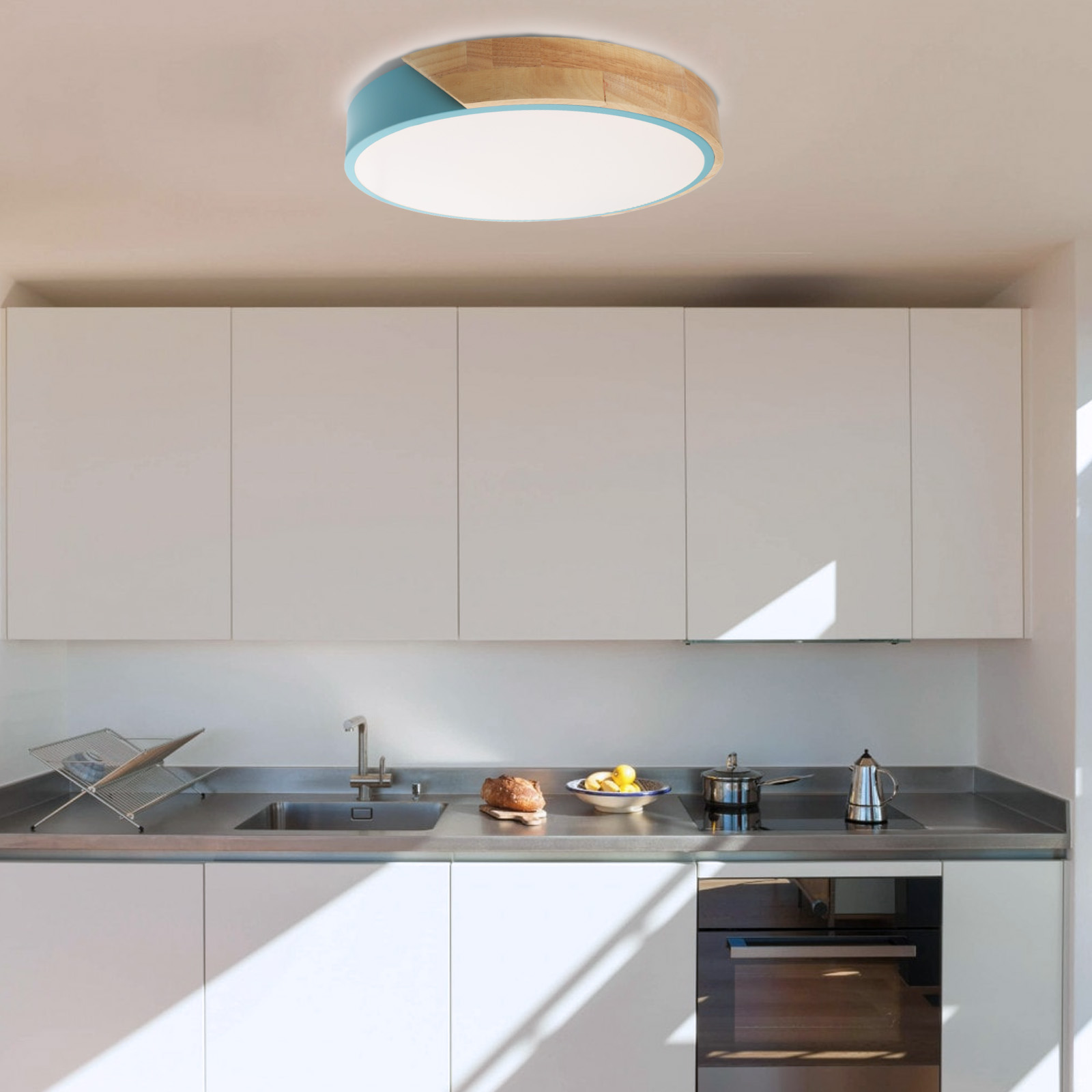 Cocina con una luz de techo redonda con borde azul y madera, sobre una encimera y una estufa.