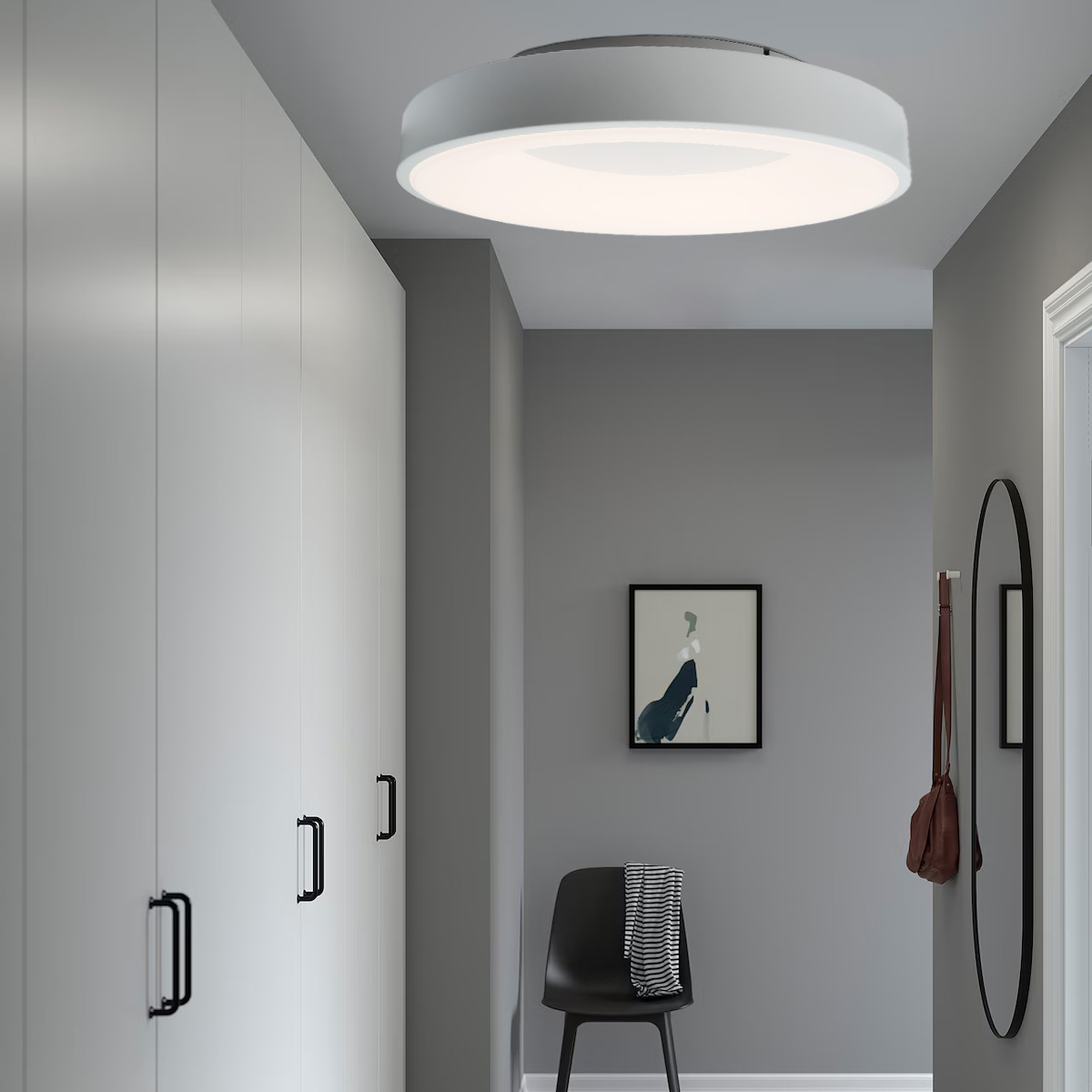 Pasillo con luz de techo, armarios blancos, espejo y silla negra.