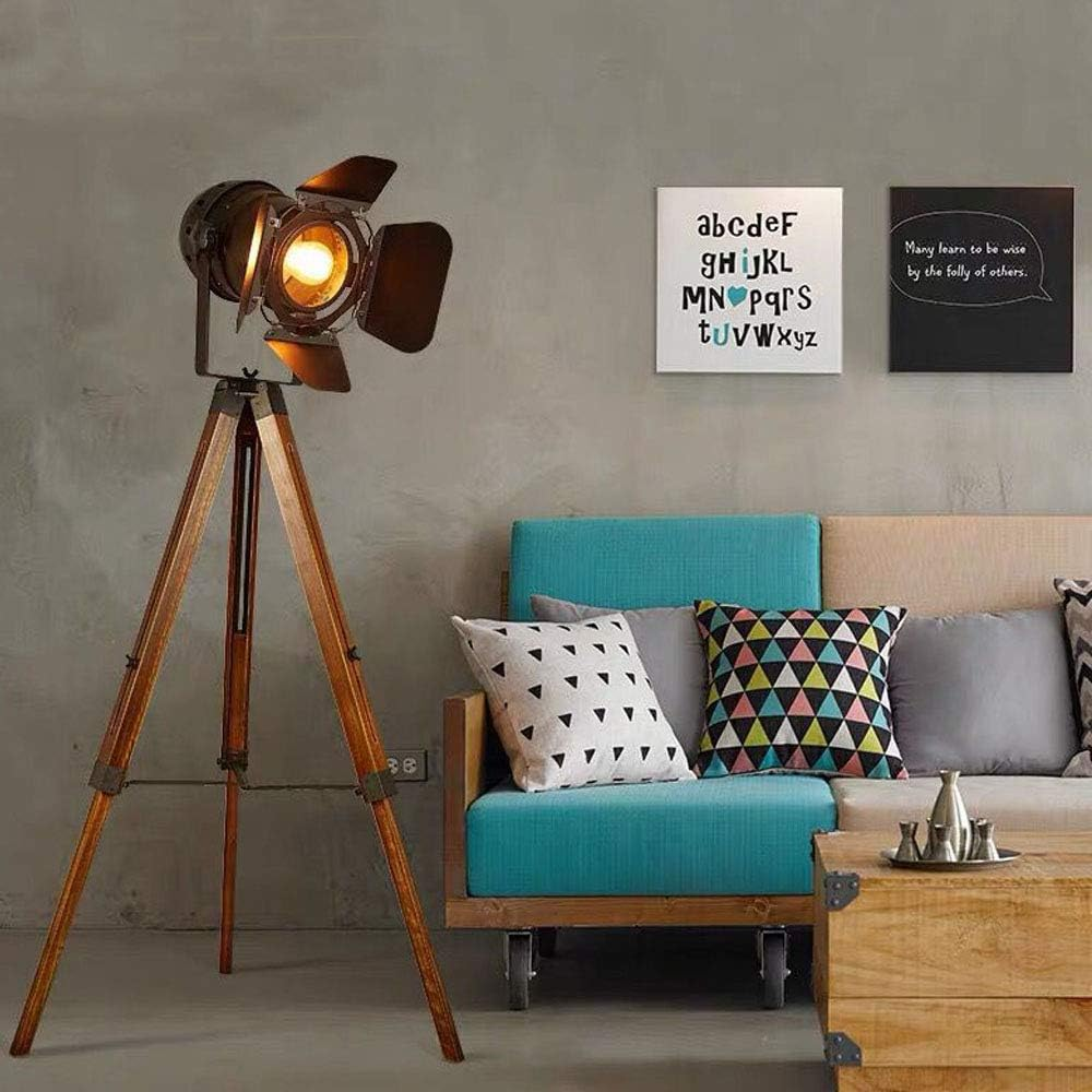Un foco en un trípode en una habitación. Se ven un sofá azul y arte en la pared. Una mesa de centro al frente.
