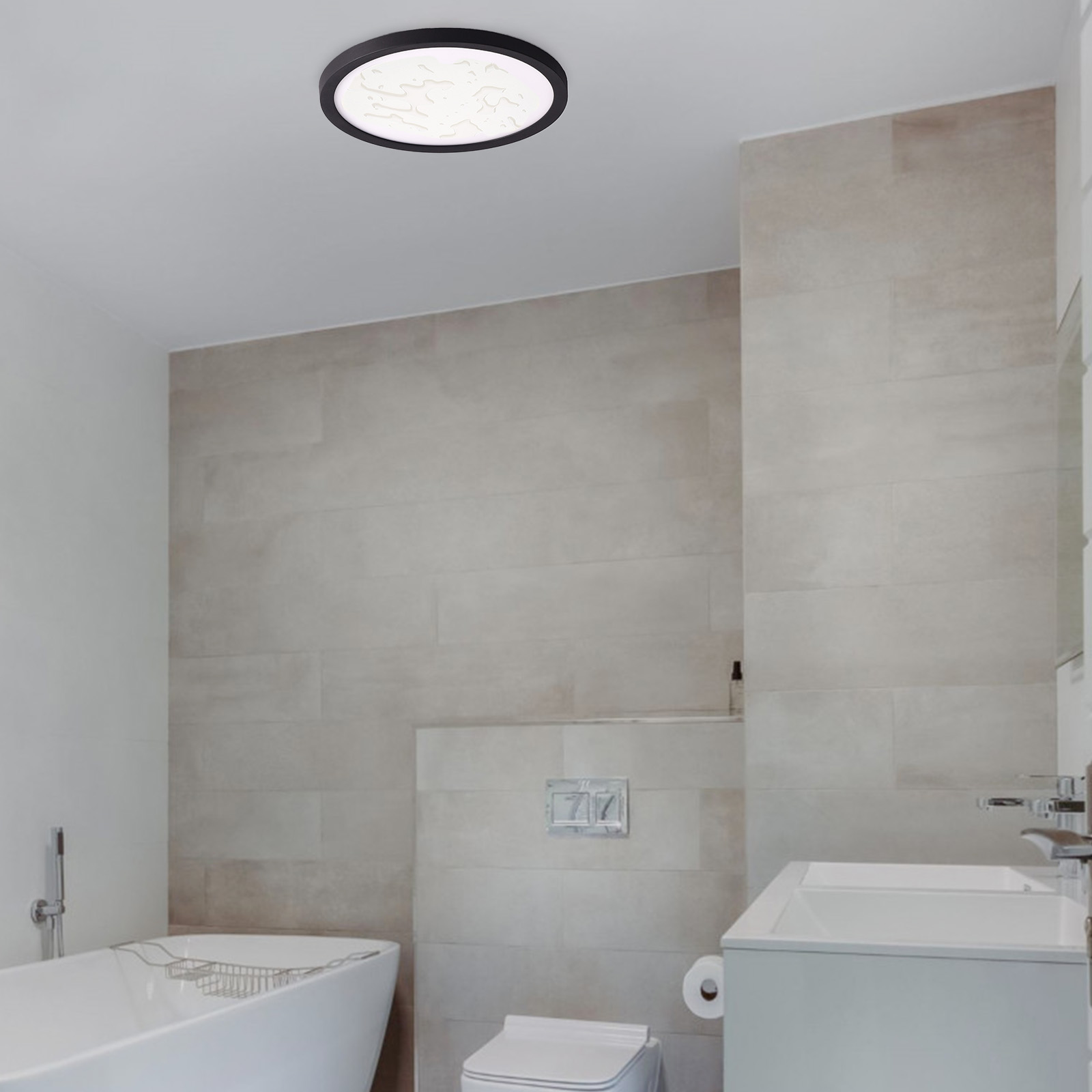 Un baño moderno con una luz de techo. Azulejos beige, una bañera blanca y un lavabo son visibles.