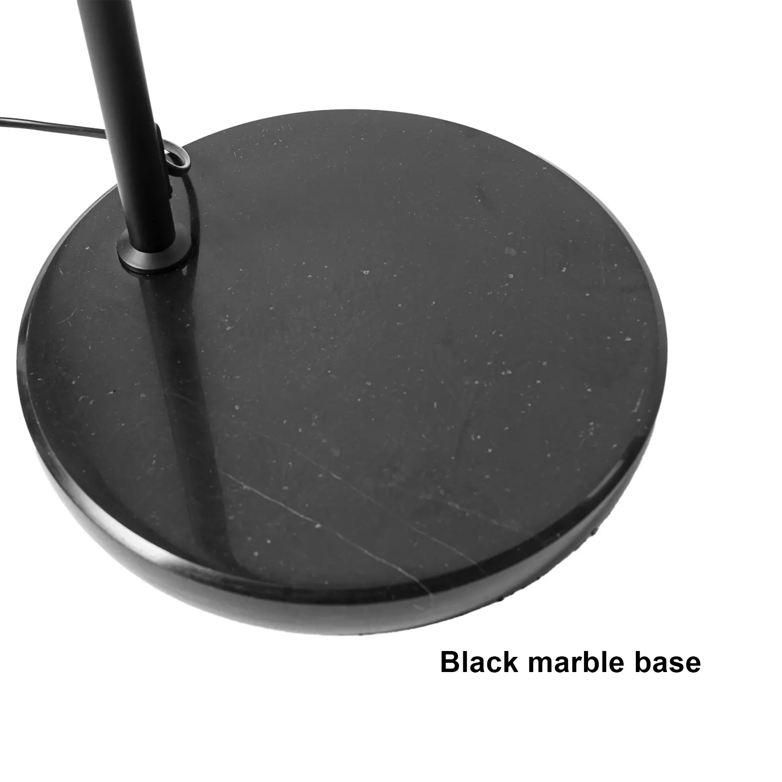 Una base de lámpara redonda de mármol negro. La base está sobre una superficie blanca.