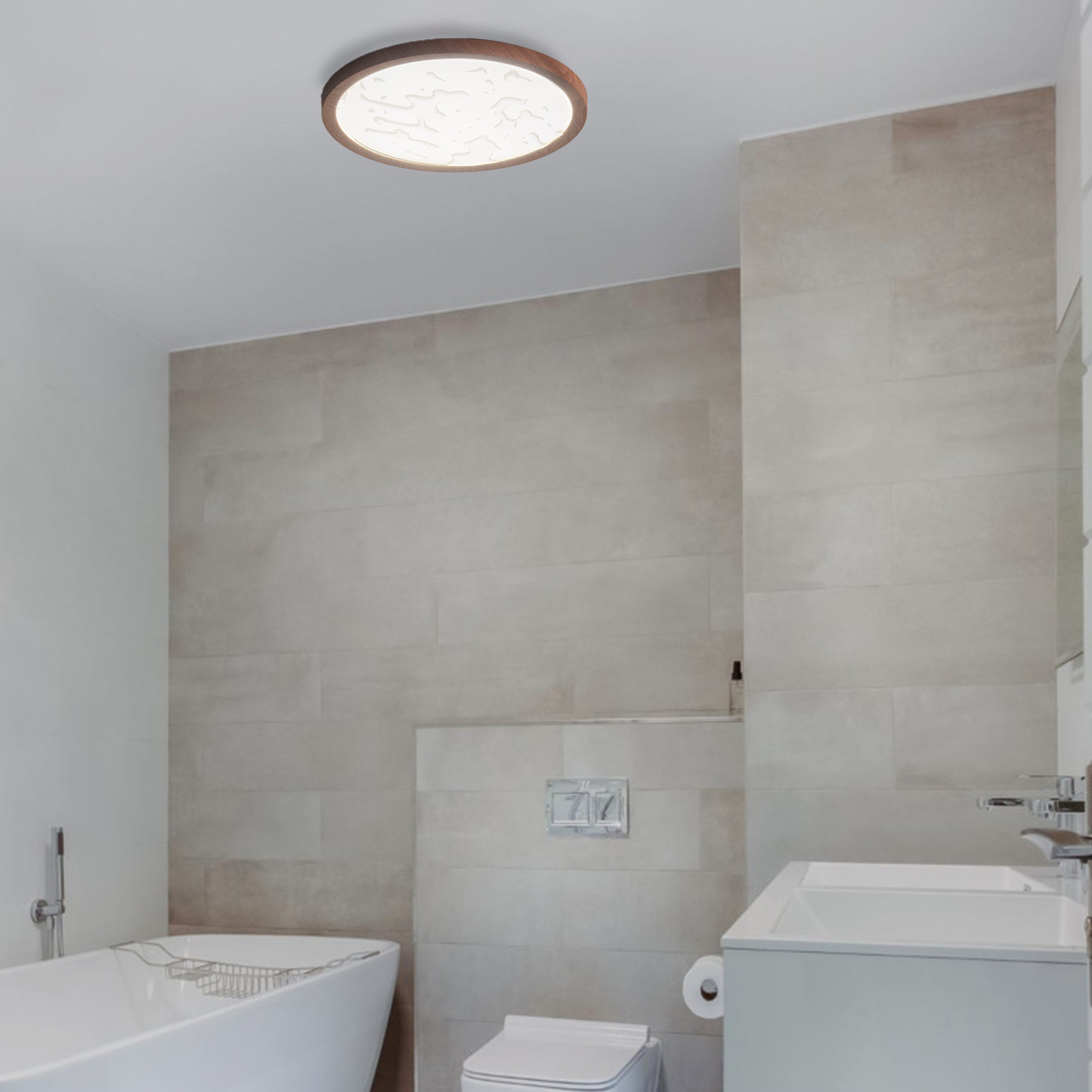 Un baño con una luz de techo. Se ven un inodoro, un lavabo y una bañera blancos. Paredes con azulejos beige.