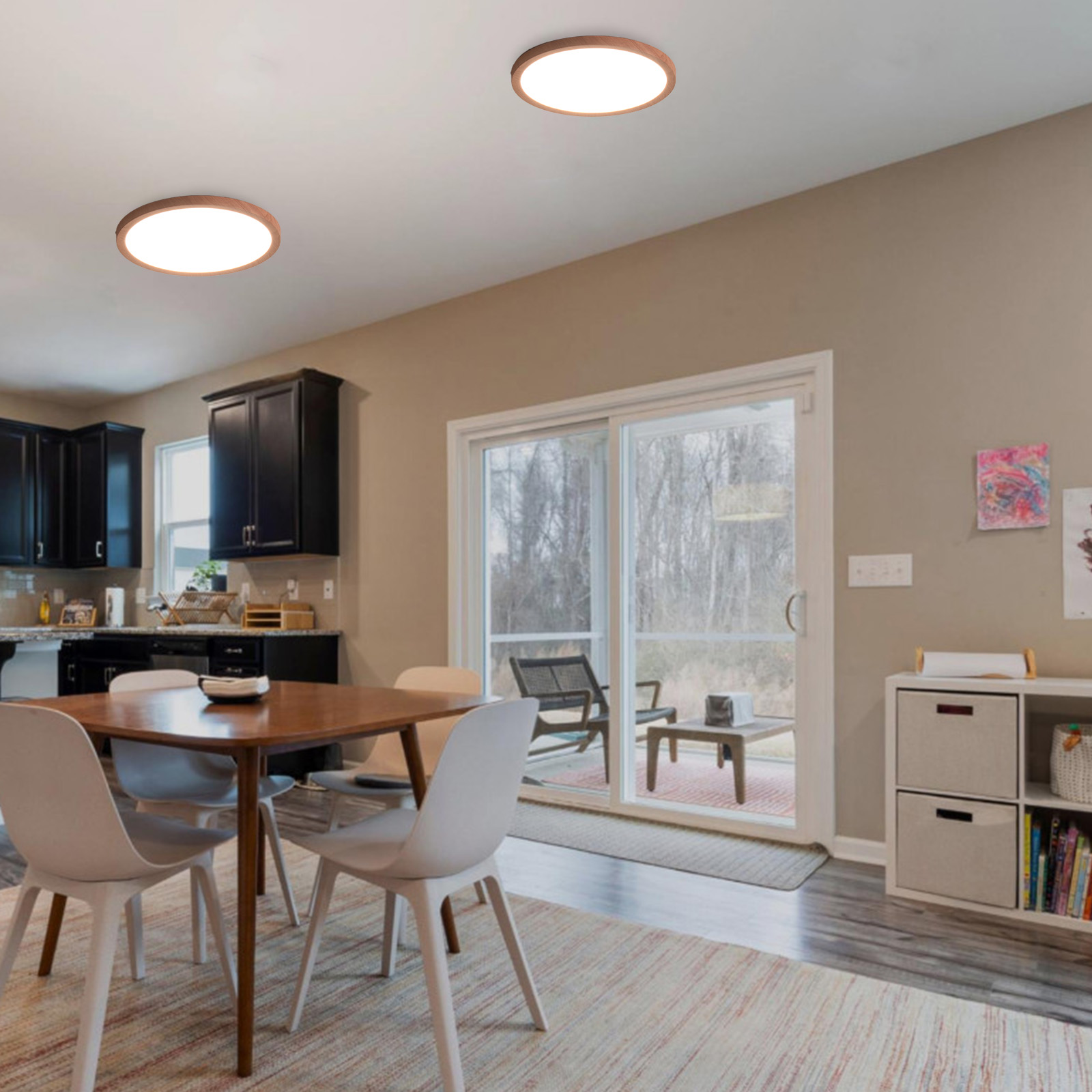 Un área de cocina y comedor con dos luces de techo, una mesa, sillas y vista al exterior.