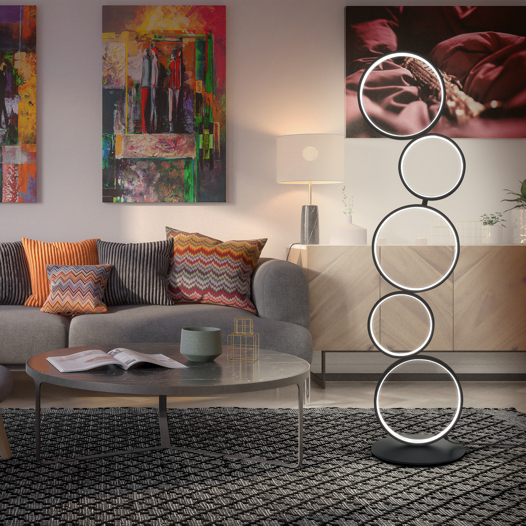 Sala de estar con lámpara de pie moderna con diseño circular. Incluye obras de arte y sofá con almohadas.