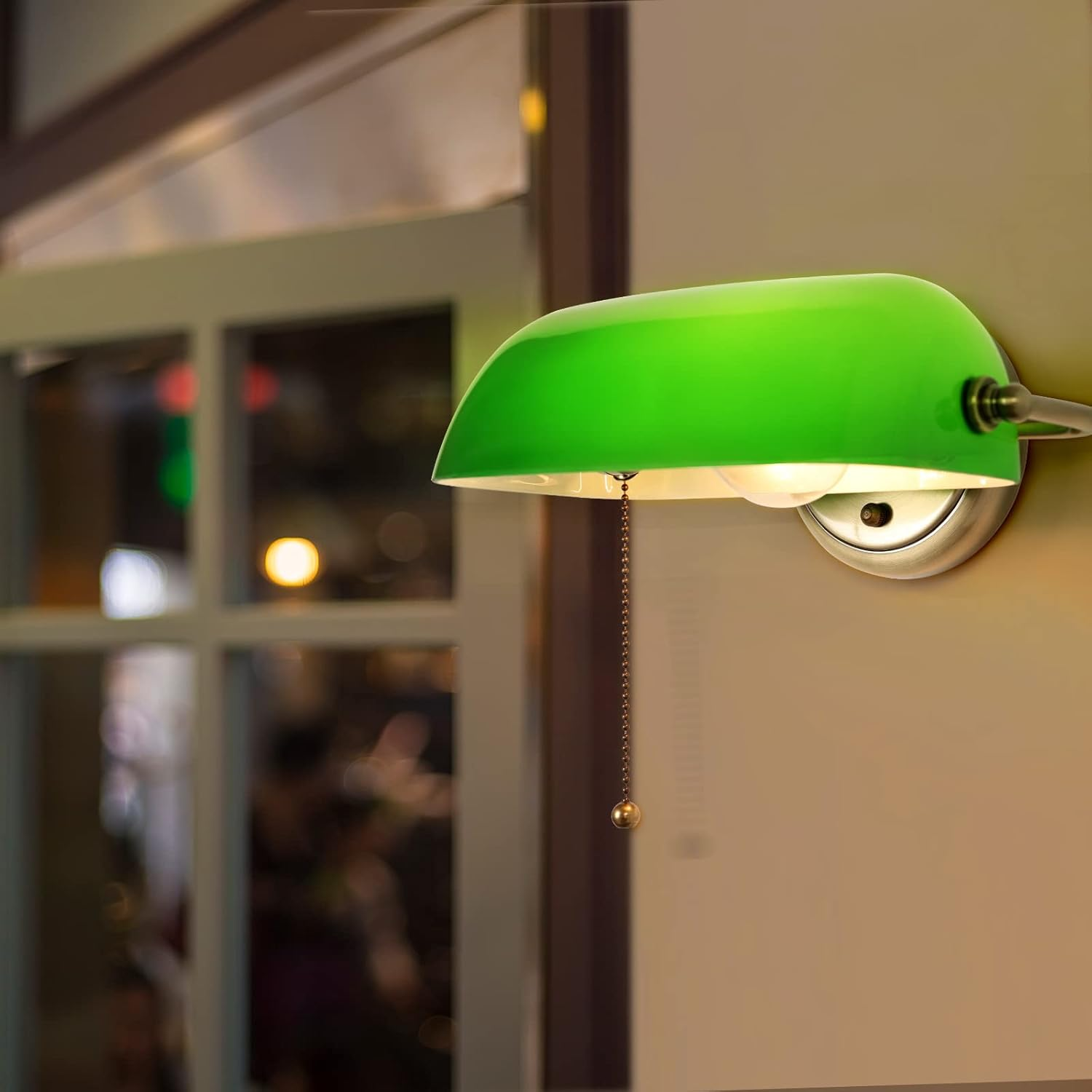 Lámpara de pared verde con cadena, en una pared cerca de una ventana y luz.