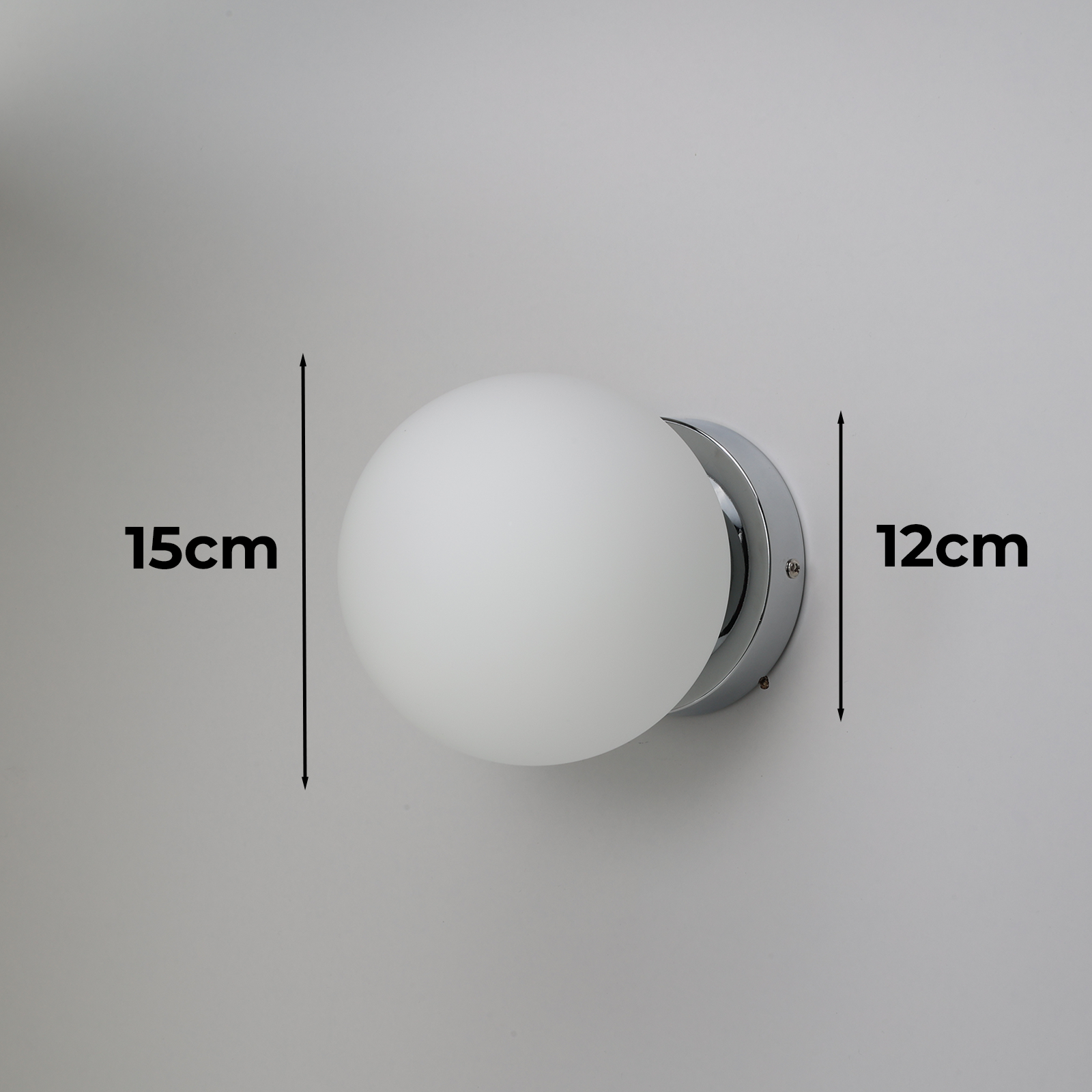 Lámpara de pared con bombilla redonda blanca. Las dimensiones son 15 cm de alto y 12 cm de ancho, sobre fondo blanco.