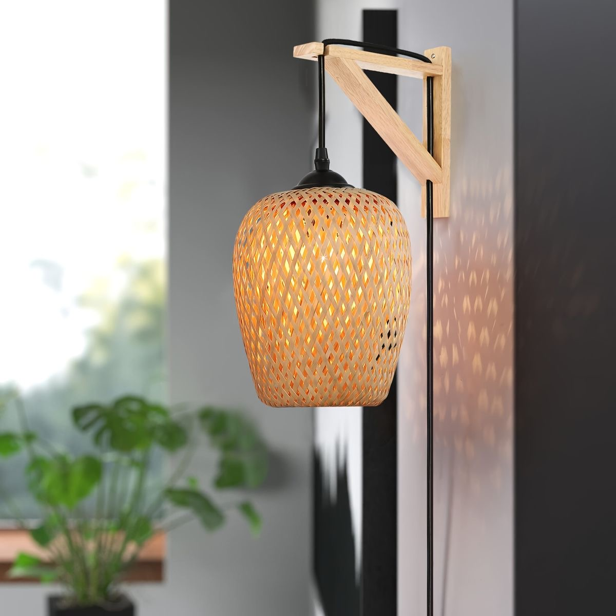 Una pantalla de lámpara de bambú tejido cuelga de un soporte de madera en la pared. La luz brilla a través del tejido, creando patrones.