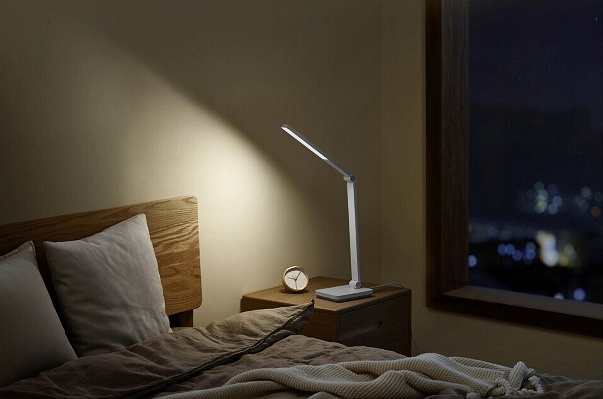 Schlafzimmer: Lampe auf Nachttisch, Bett und Fenster mit Nachtansicht.