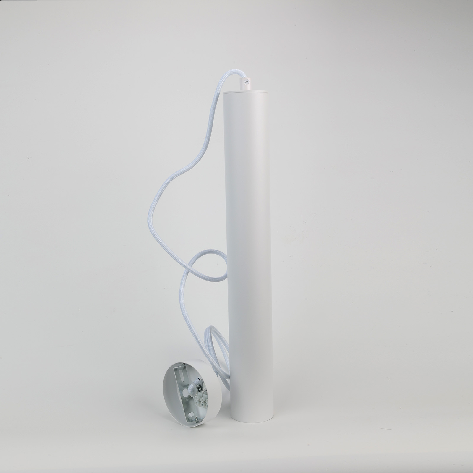 Una lámpara colgante cilíndrica blanca, desmontada, con un cable blanco.