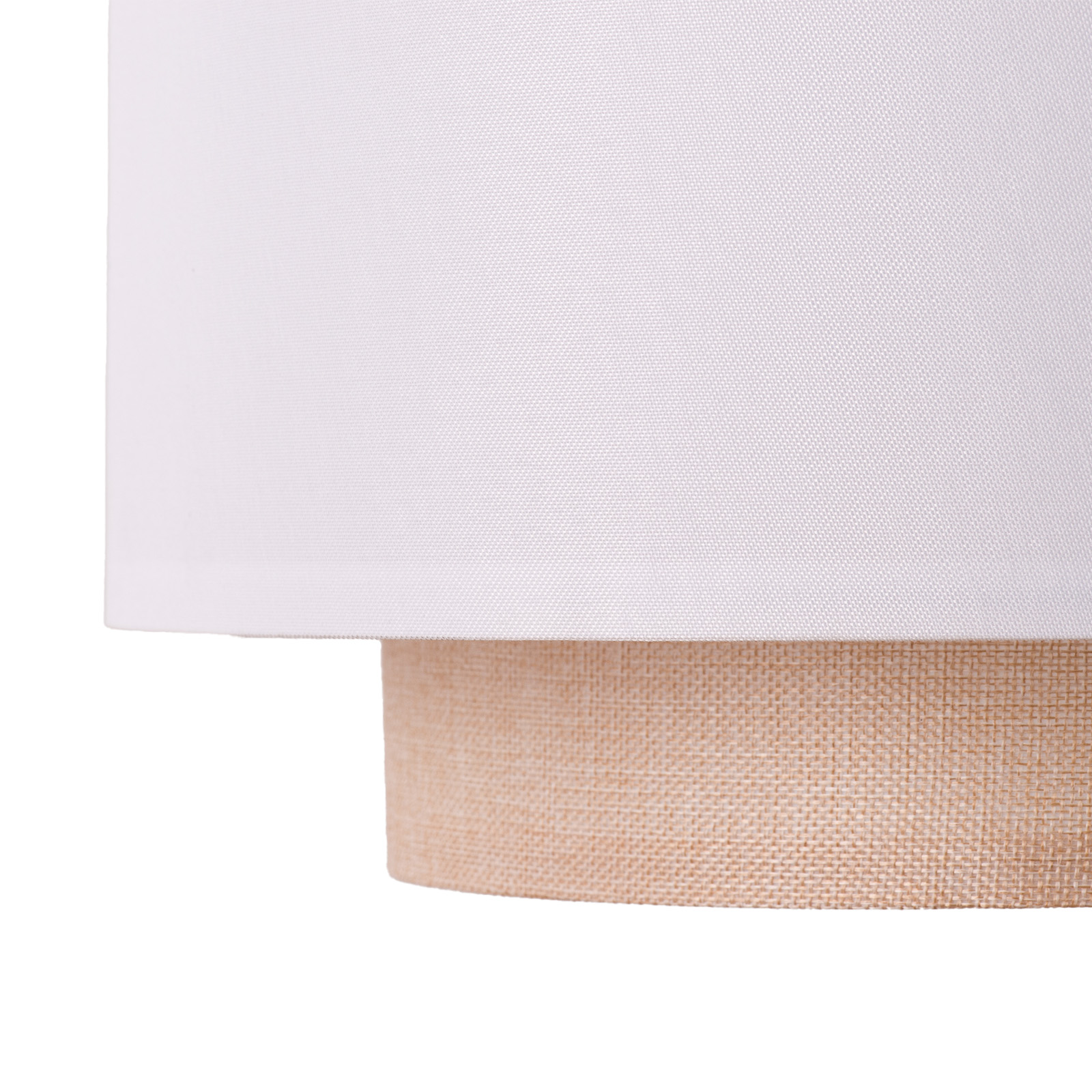 Primer plano de una pantalla de lámpara. Tiene una parte superior blanca y una base tejida beige.