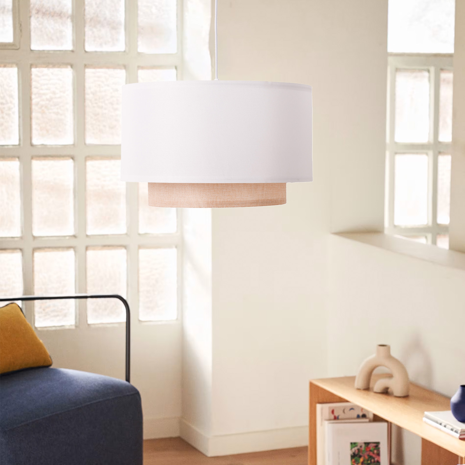 Una lámpara colgante con pantalla superior blanca e inferior beige, en una habitación luminosa.