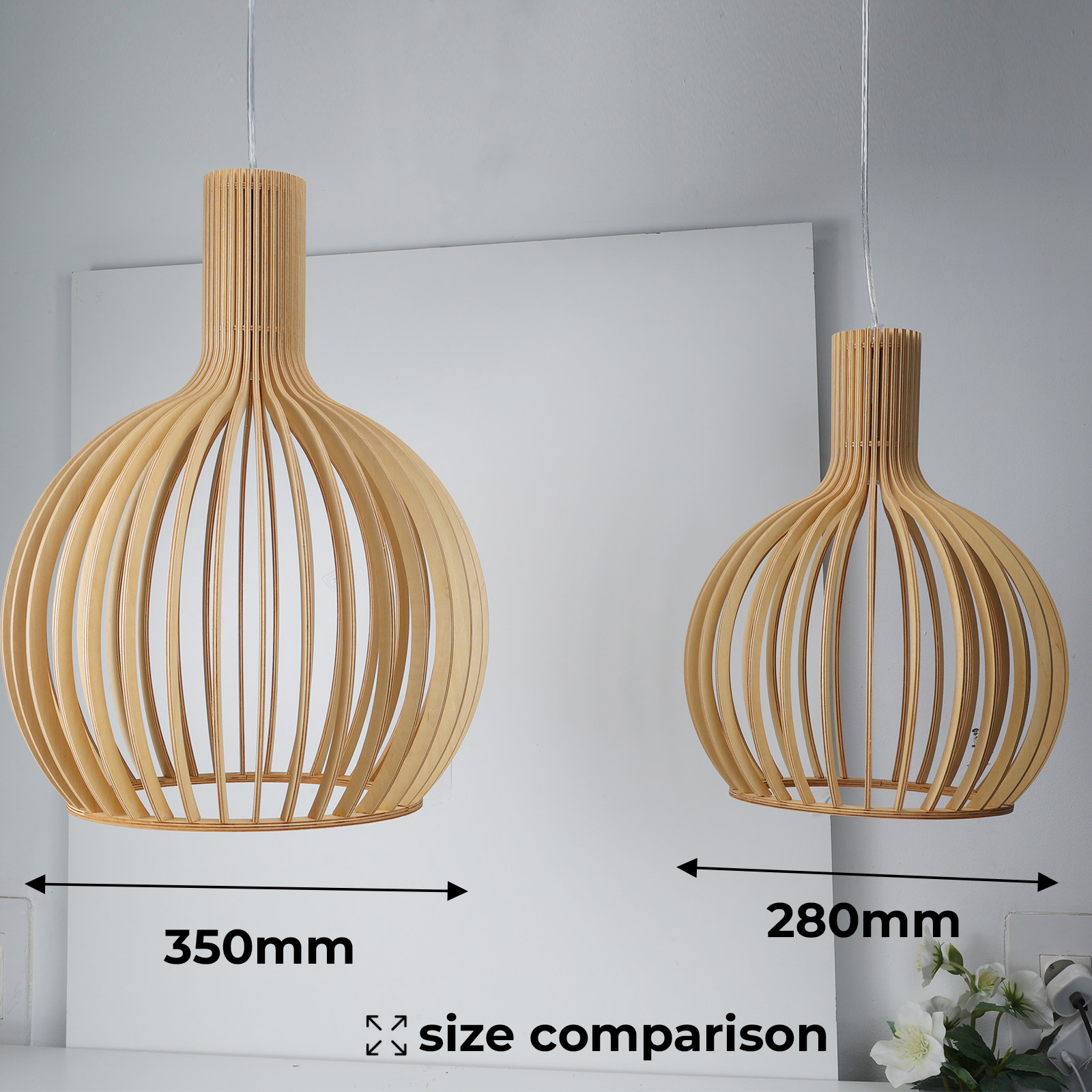 Dos lámparas colgantes de madera cuelgan, una más grande y otra más pequeña. La diferencia de tamaño se enfatiza con mediciones.