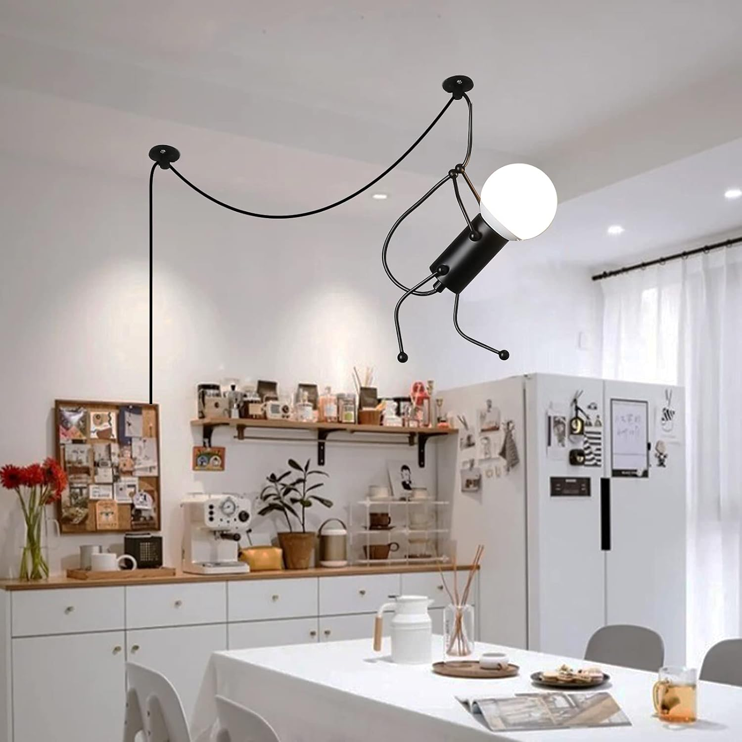 Una lámpara negra cuelga del techo de una cocina. Parece una figura colgando del techo.