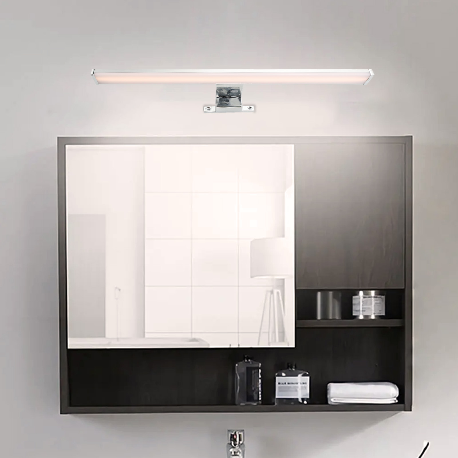 Una lámpara de espejo instalada encima de un espejo de baño, junto a estantes y accesorios.