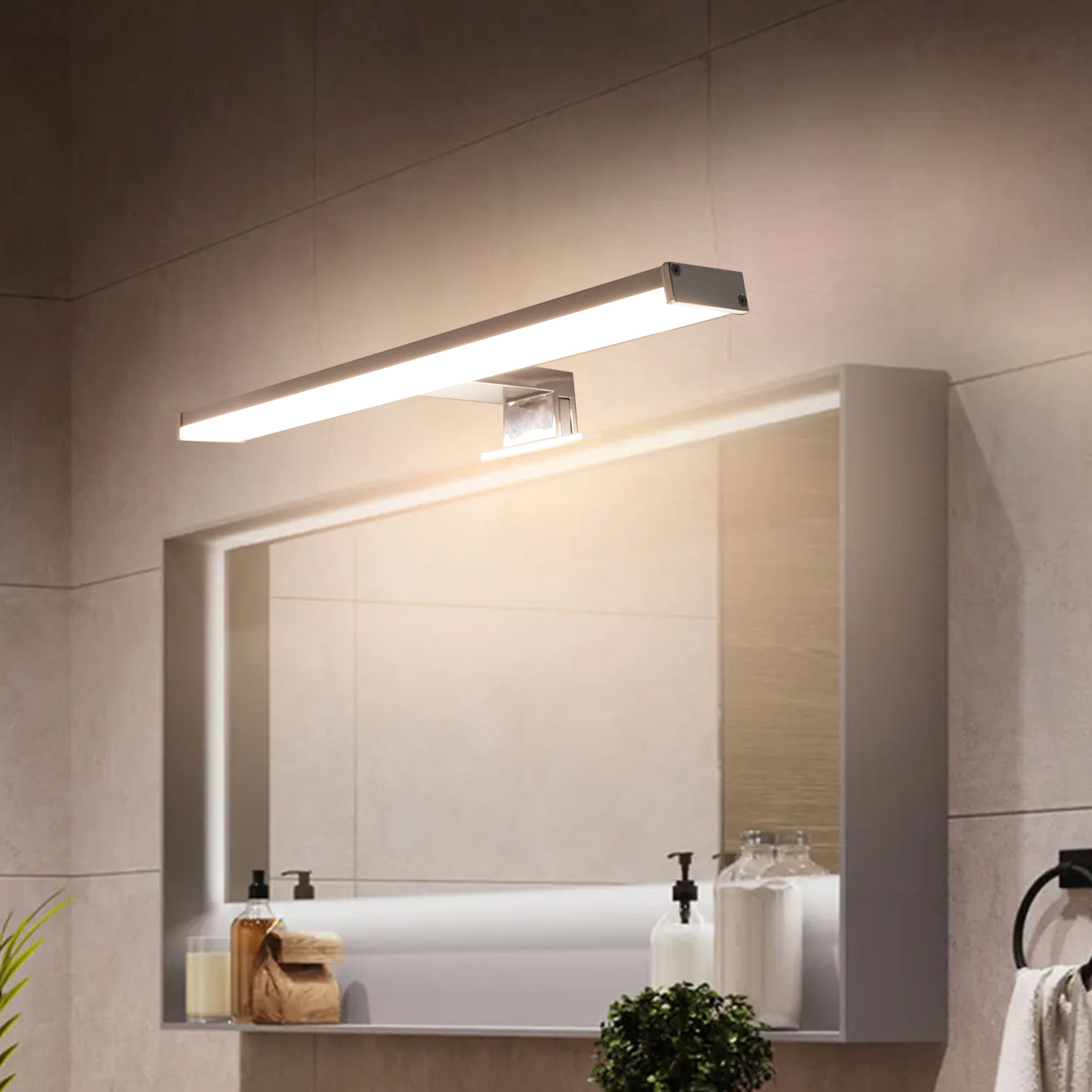 Una lámpara de espejo sobre un espejo en un baño. La lámpara está encendida.