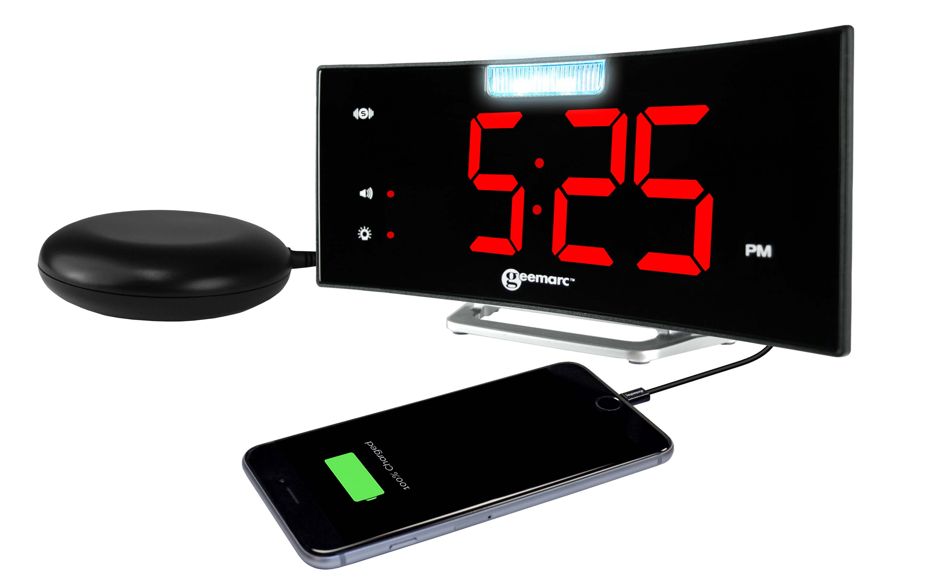 Un orologio digitale con numeri rossi, che carica un telefono e un pad vibrante nero.