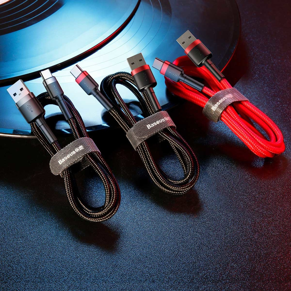 Trzy czarne i czerwone kable USB spięte razem, z paskiem Baseus, na ciemnej powierzchni.