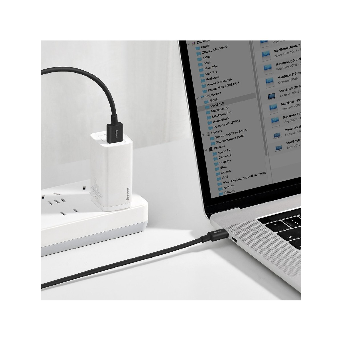 Laptop ładuje się czarnym kablem podłączonym do białego zasilacza i laptopa.