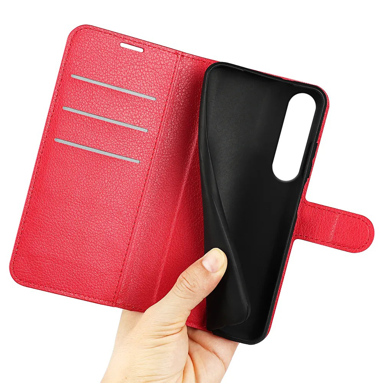 Een rode telefoonhoes, geopend om een zwart interieur en een hand die een telefoon vasthoudt, te onthullen.