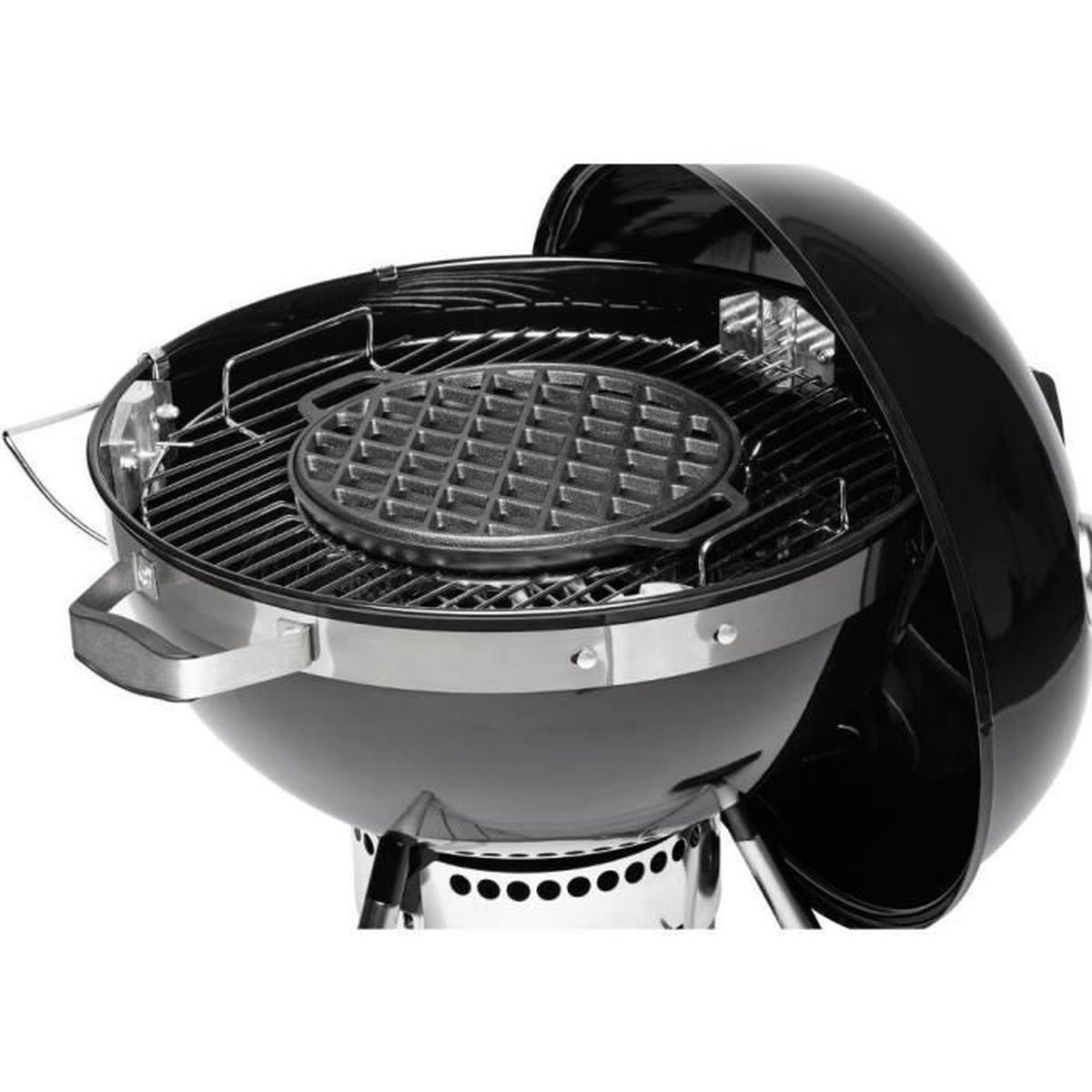 Black charcoal grill, open, with a waffle iron inside, on the grill grate.