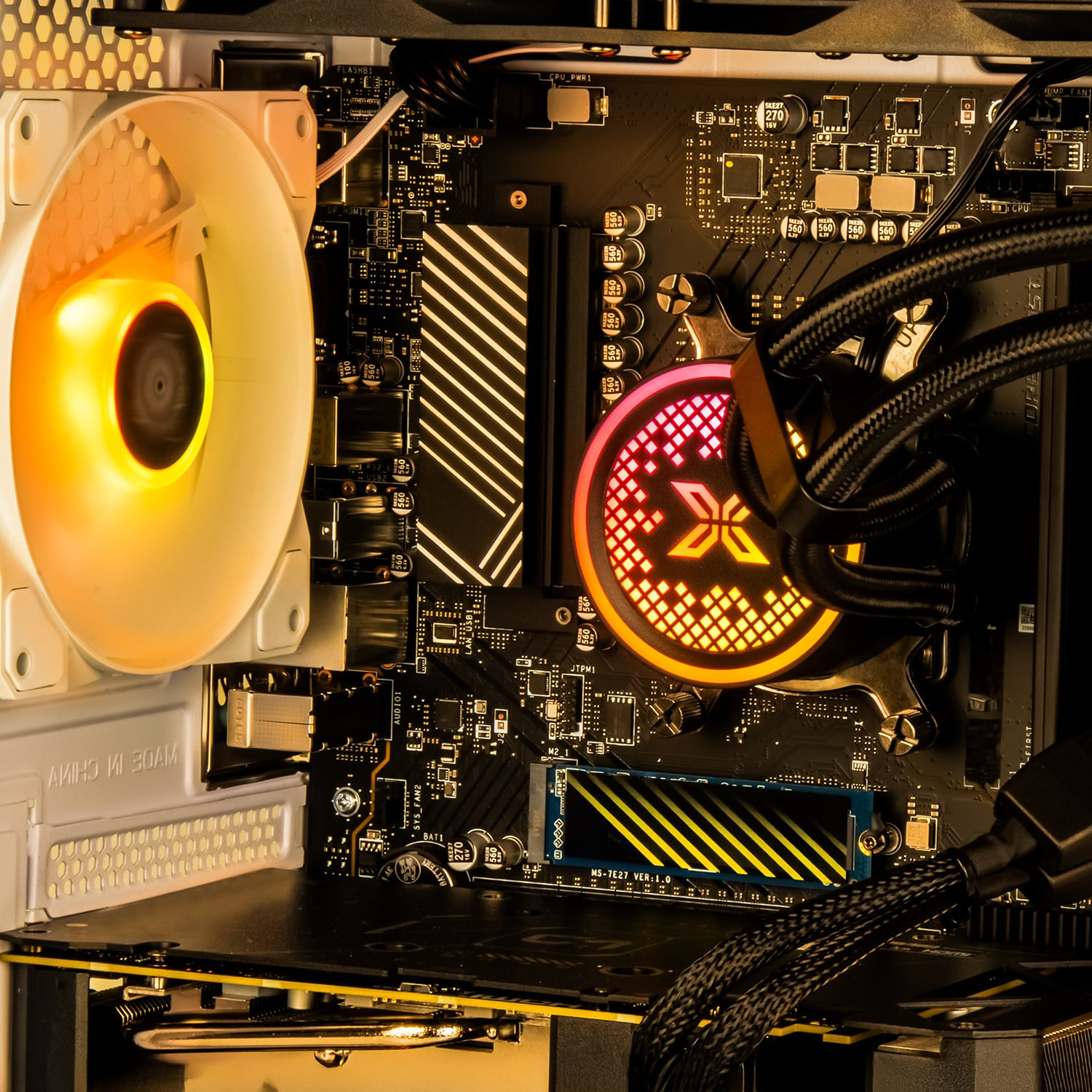 Computer interior with components including fan, motherboard, and liquid cooler.
