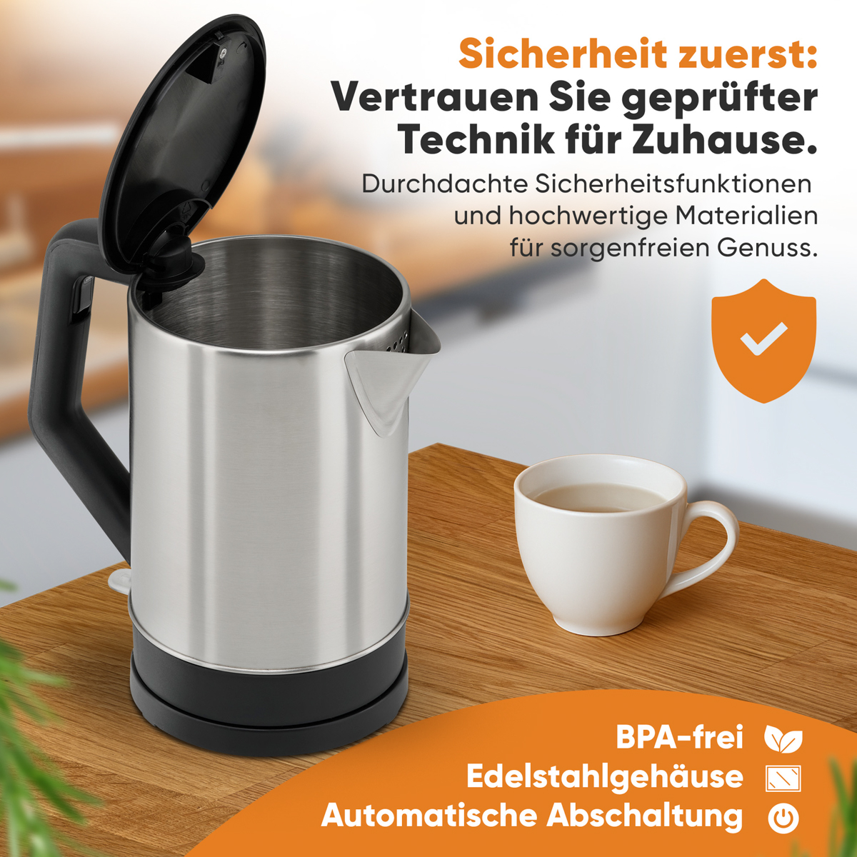 Czajnik ze stali nierdzewnej z tekstem i ikonami opisującymi funkcje. Z prawej strony biały kubek.