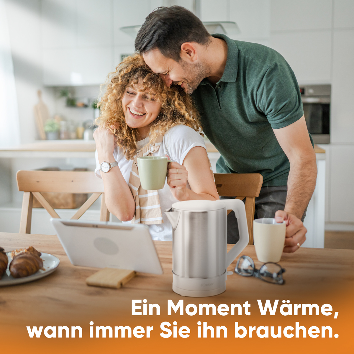 Para obejmuje się przy stole. Na stole czajnik, tablet, kubki i okulary.