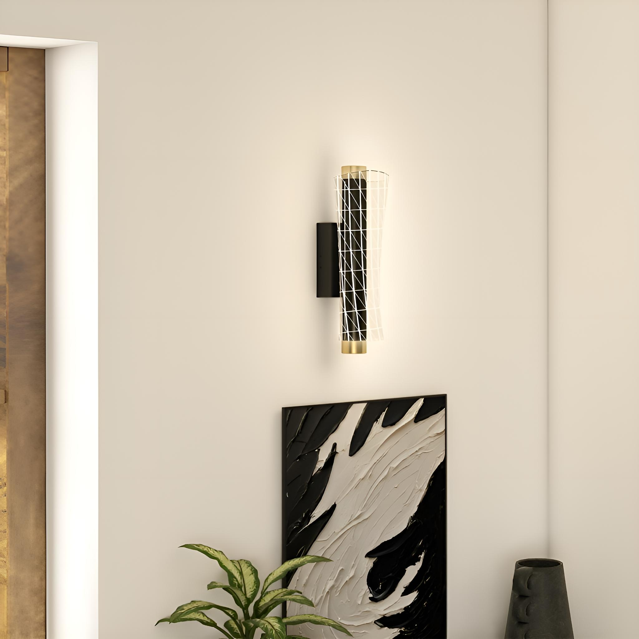Eine Wandlampe mit Metallrahmen und weißem Gitter über einem schwarzen Zylinder. Darunter ein schwarzes Gemälde.
