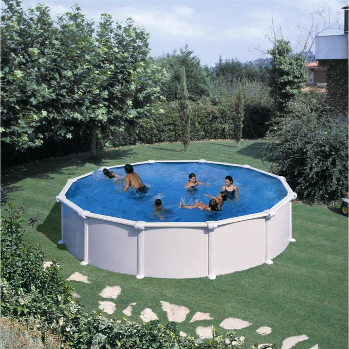 Personas nadando en una piscina redonda elevada, rodeada de césped verde y árboles.