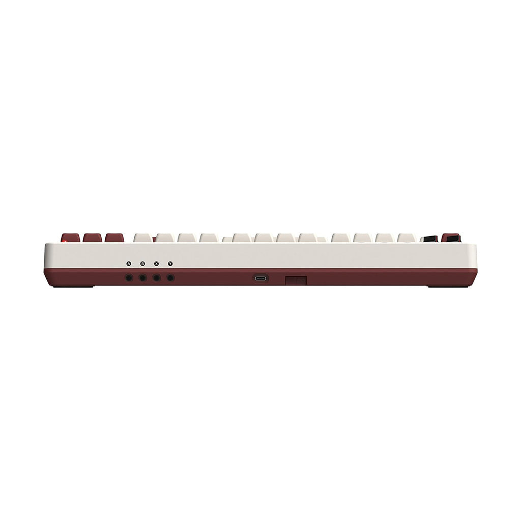 Widok z boku klawiatury retro z czerwonymi akcentami i białymi klawiszami, pokazujący port USB.